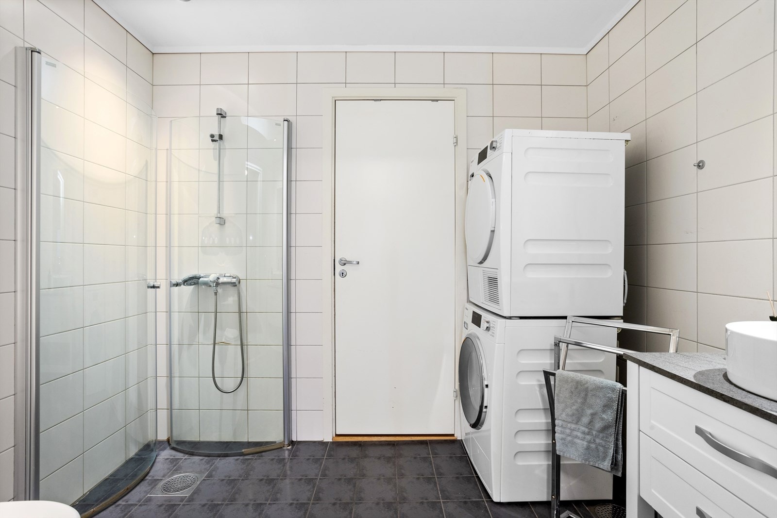 Baderommet i 1. etasje er utstyrt med dusj, toalett og rommet har flislagte vegger og flislagte gulv med elektrisk gulvvarme. Baderommet har derfor innfelte downlights med nivåjustering i himlingen. Galleribilde