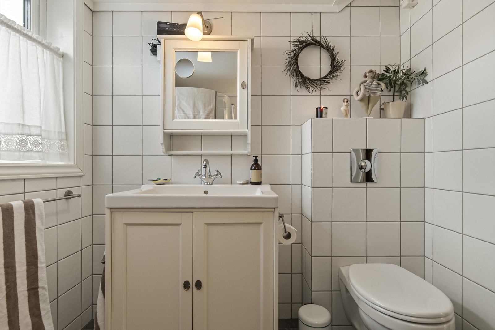 Badet er innredet med vegghengt toalett, servant i innredning og dusjhjørne Galleribilde