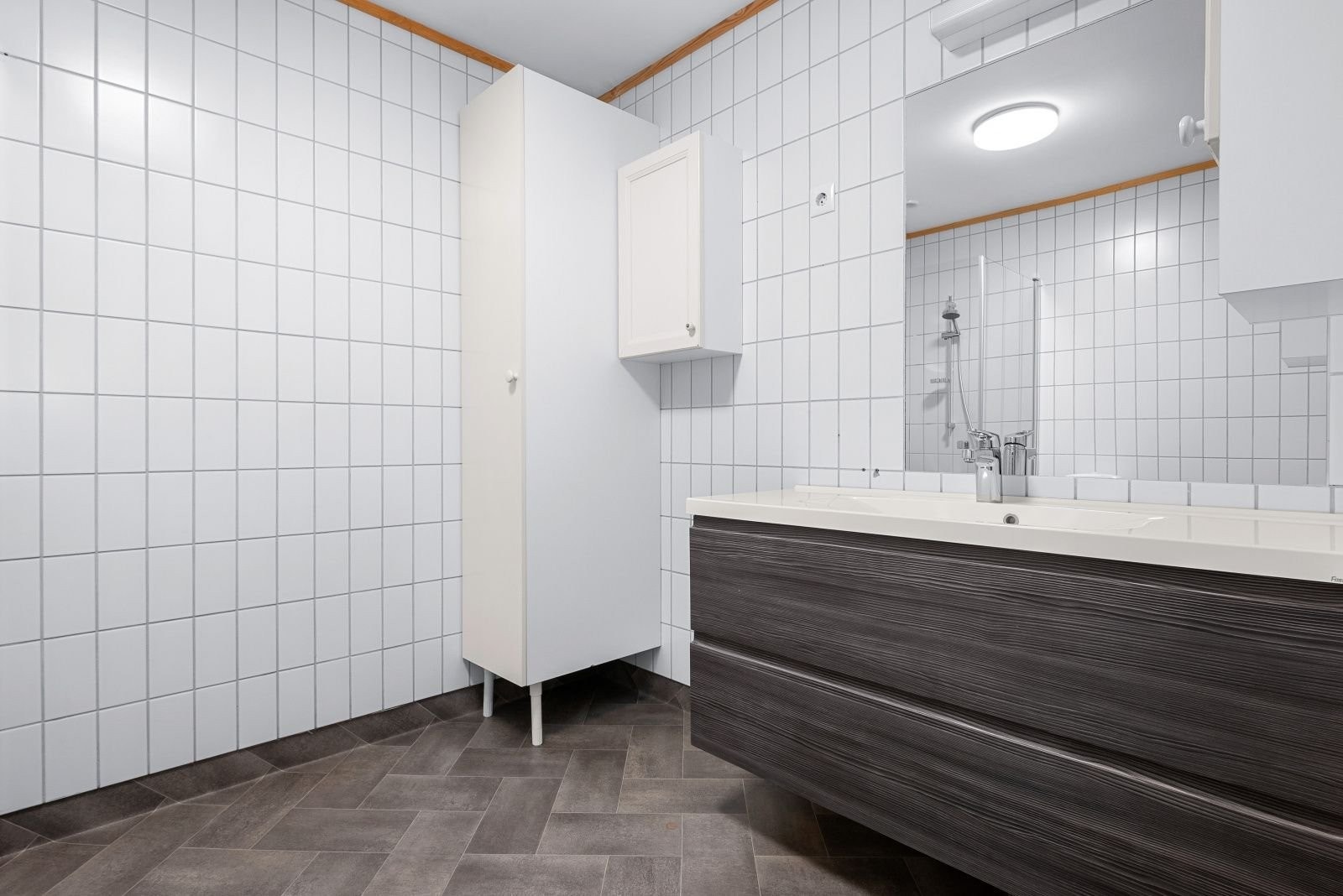 Med gode skuffer i baderomsinnredning og separat høyskap er det godt med skapplass på badet. I tillegg er det en skuffeseksjon i hjørnet ved skyvedør, den vises ikke på bildet. Galleribilde