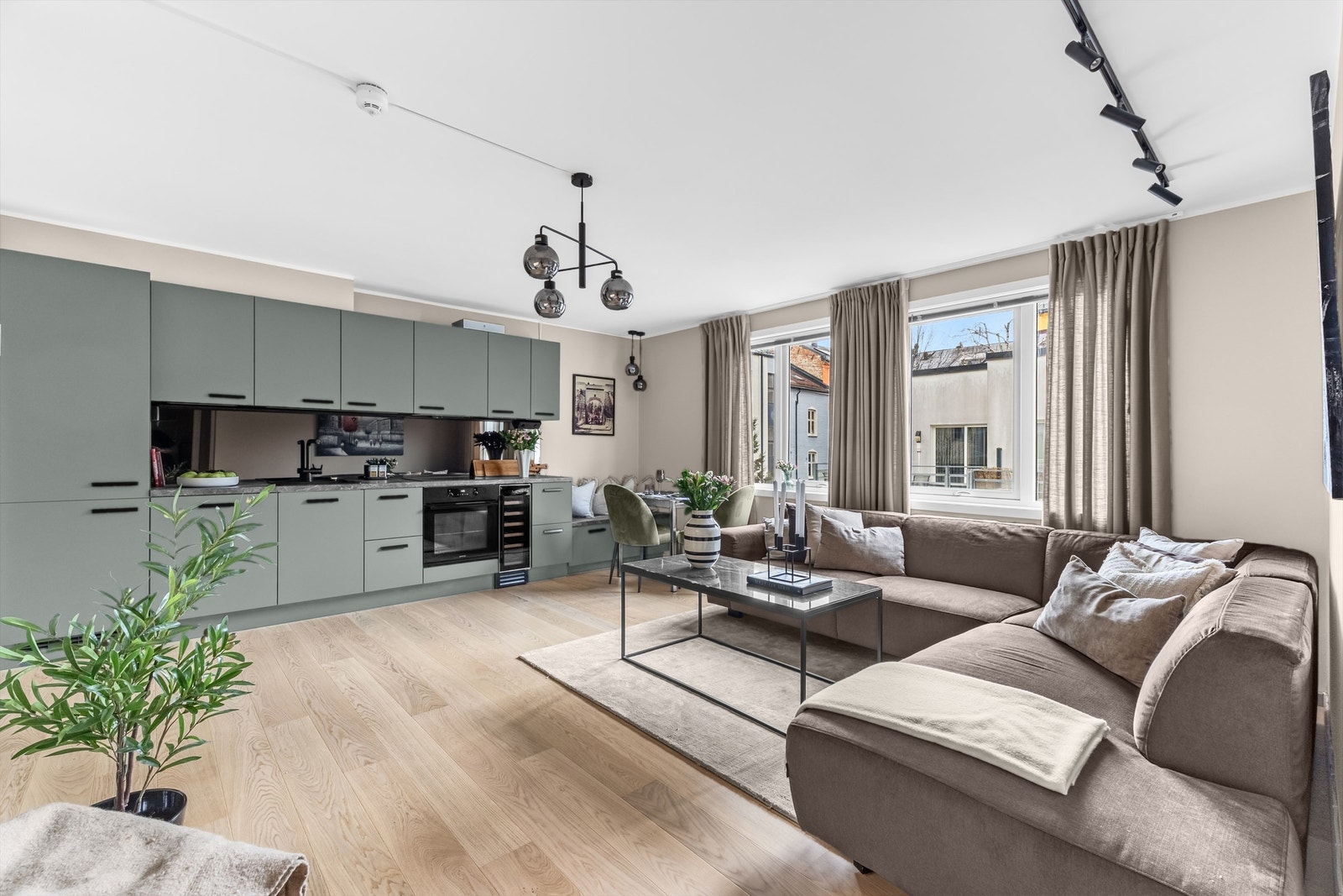 Leilighetens åpne stue- og kjøkkenløsning skaper en lun og sosial atmosfære. Galleribilde