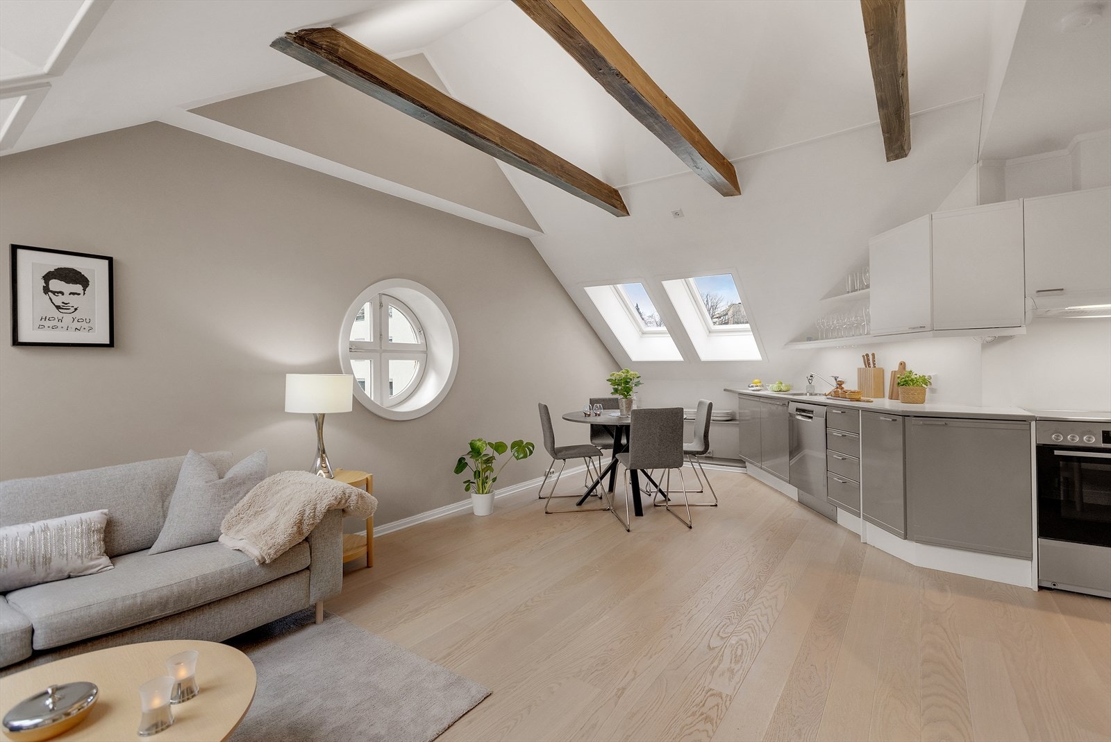 Leiligheten har en åpen og luftig stue-/kjøkkenløsning med skråtak og takvinduer som slipper inn rikelig med naturlig lys og gir boligen en helt egen atmosfære. Galleribilde