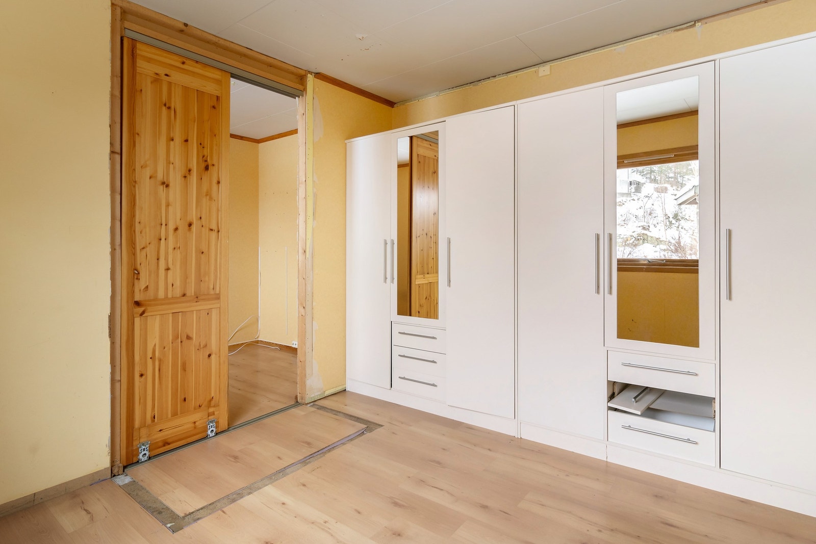 Soverom nr. 1 med garderobeskap. Inngangsdør bak garderobeskapene. Galleribilde