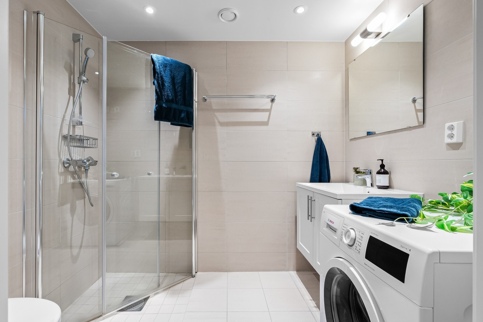 Lekkert flislagt baderom med gulvvarme, downlights og varme i gulv Galleribilde