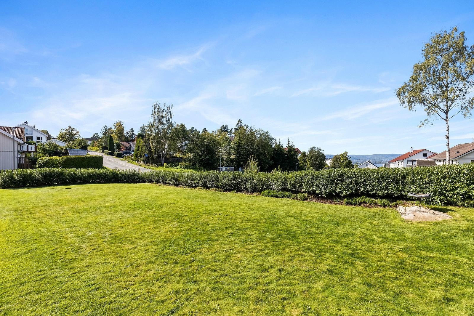 Pent opparbeidet tomt med stor plen. Galleribilde