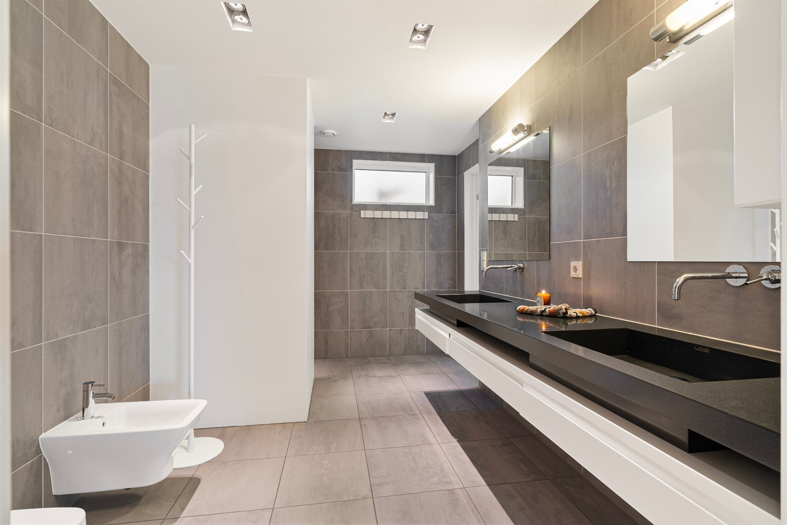 Stort en-suite bad i særklasse med lekre fliser og behagelig gulvvarme. Galleribilde