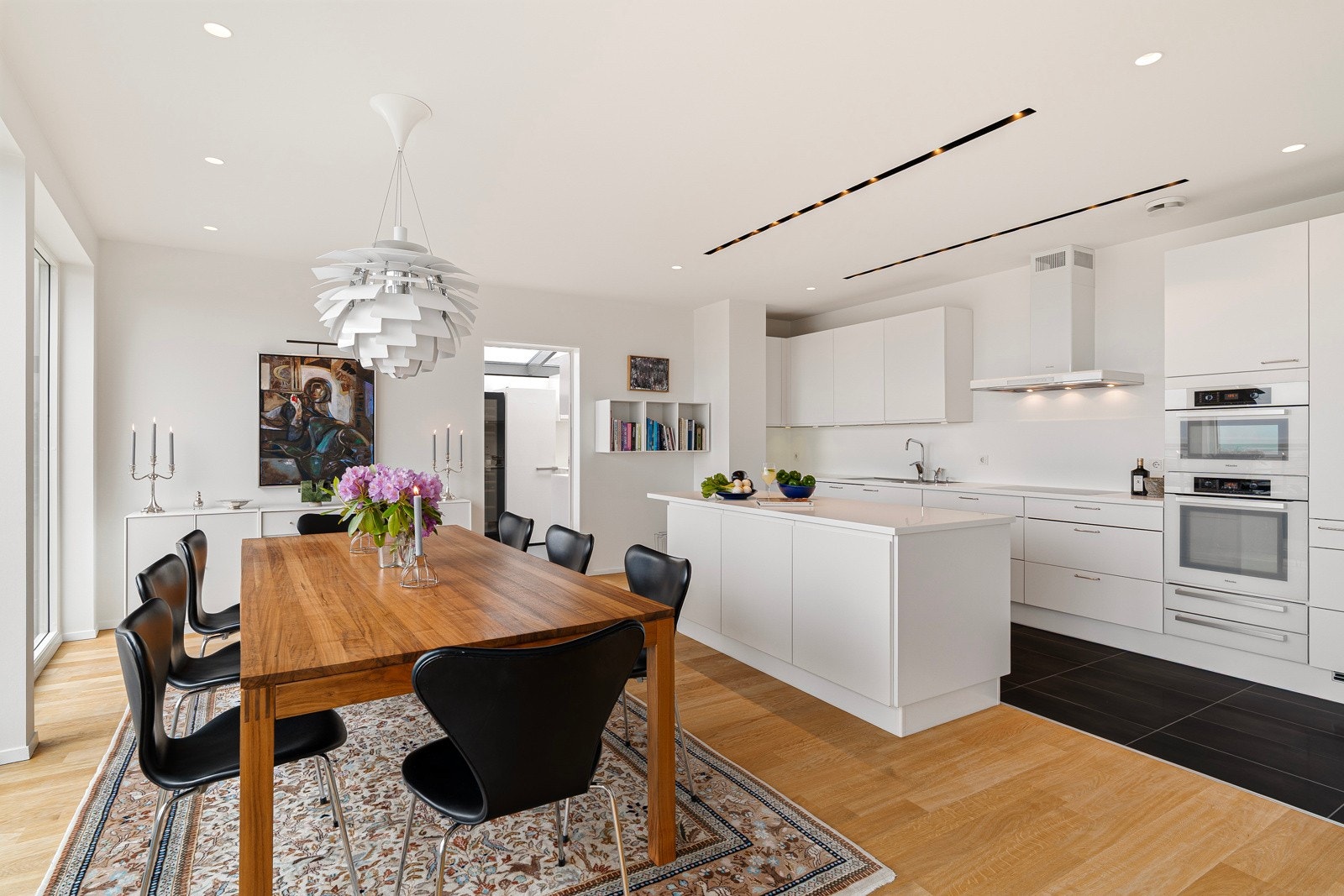 Gjennomtenkt kjøkken i stilrent design med rikelig skap- og benkeplass. Galleribilde