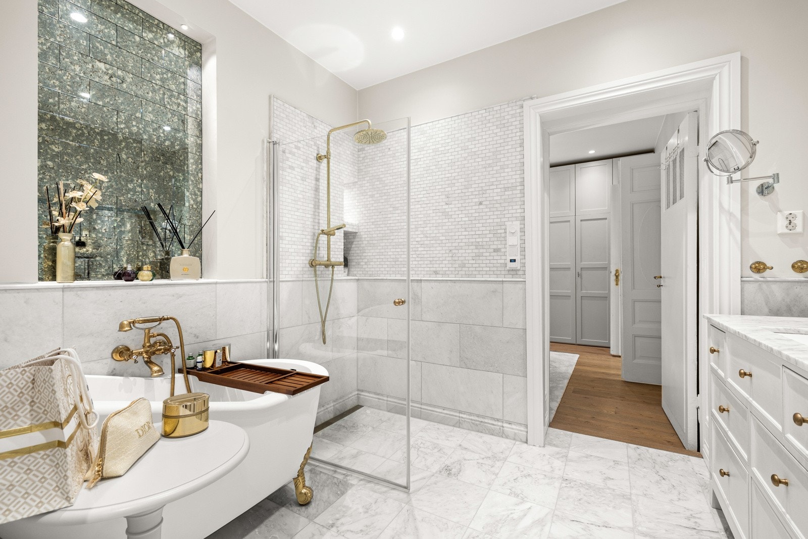 Det frittstående badekaret med dekorative gullføtter tilfører rommet et luksuriøst preg - en stilsikker kontrast til de rene linjene ellers i rommet. Galleribilde