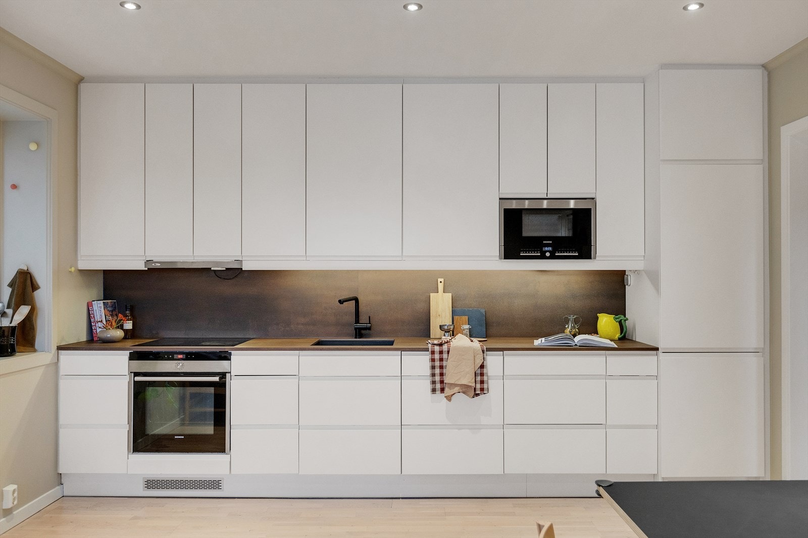 Keramisk benkeplate gir en solid og elegant arbeidsflate, med integrerte hvitevarer. Galleribilde