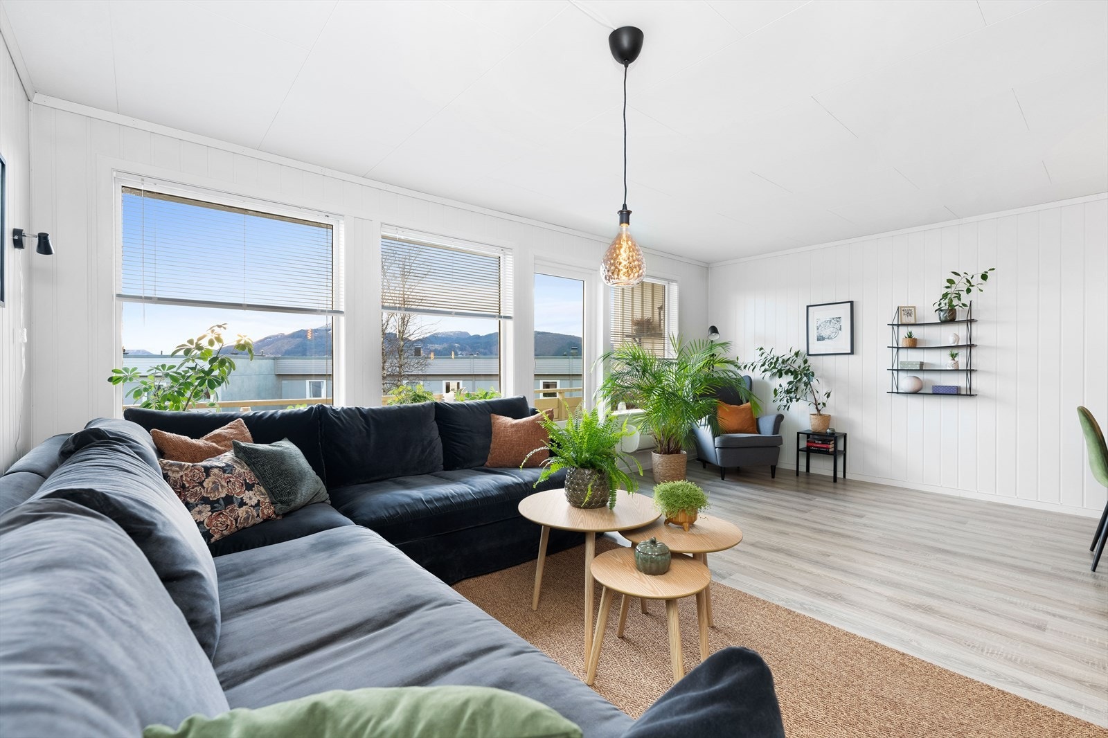 Her i stuen har man rikelig med innslipp av naturlig lys fra store vinduer vendt ut mot hage, samt oppvarming via varmepumpe. Galleribilde