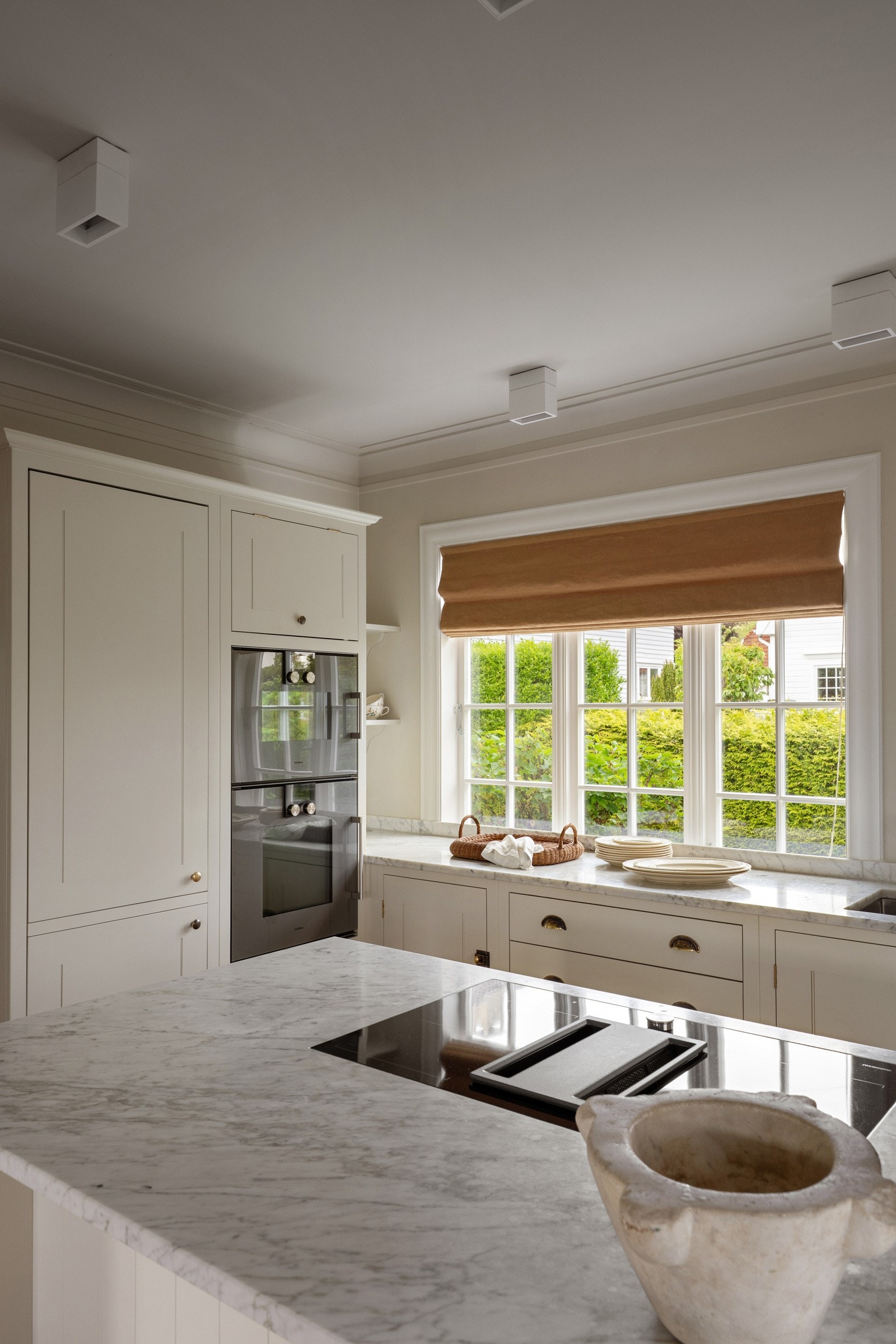 Innredningen fra British Standard, by Plain English Design har lyse, profilerte fronter og lys, mattslipt benkeplate i Carrera marmor med underlimt stålkum. Galleribilde