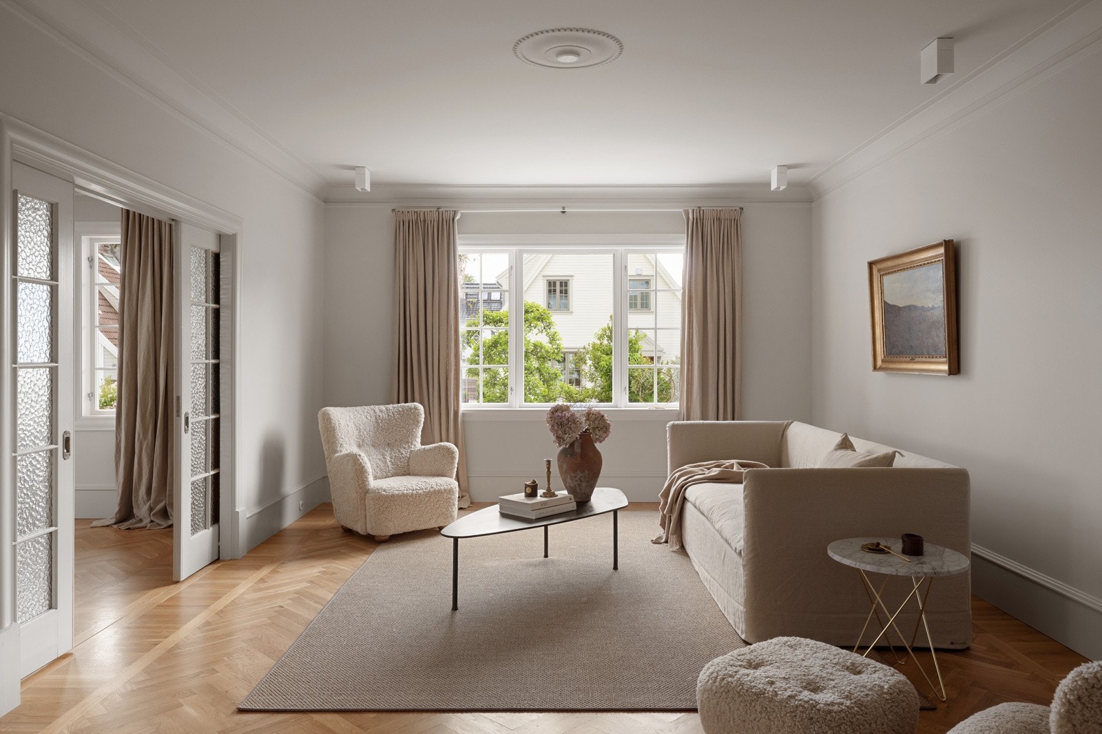 Hele første etasje ble renovert i 2019, og fremstår med tidstypiske detaljer, duse fargevalg og lekker, fiskebeinsparkett på gulv. Galleribilde