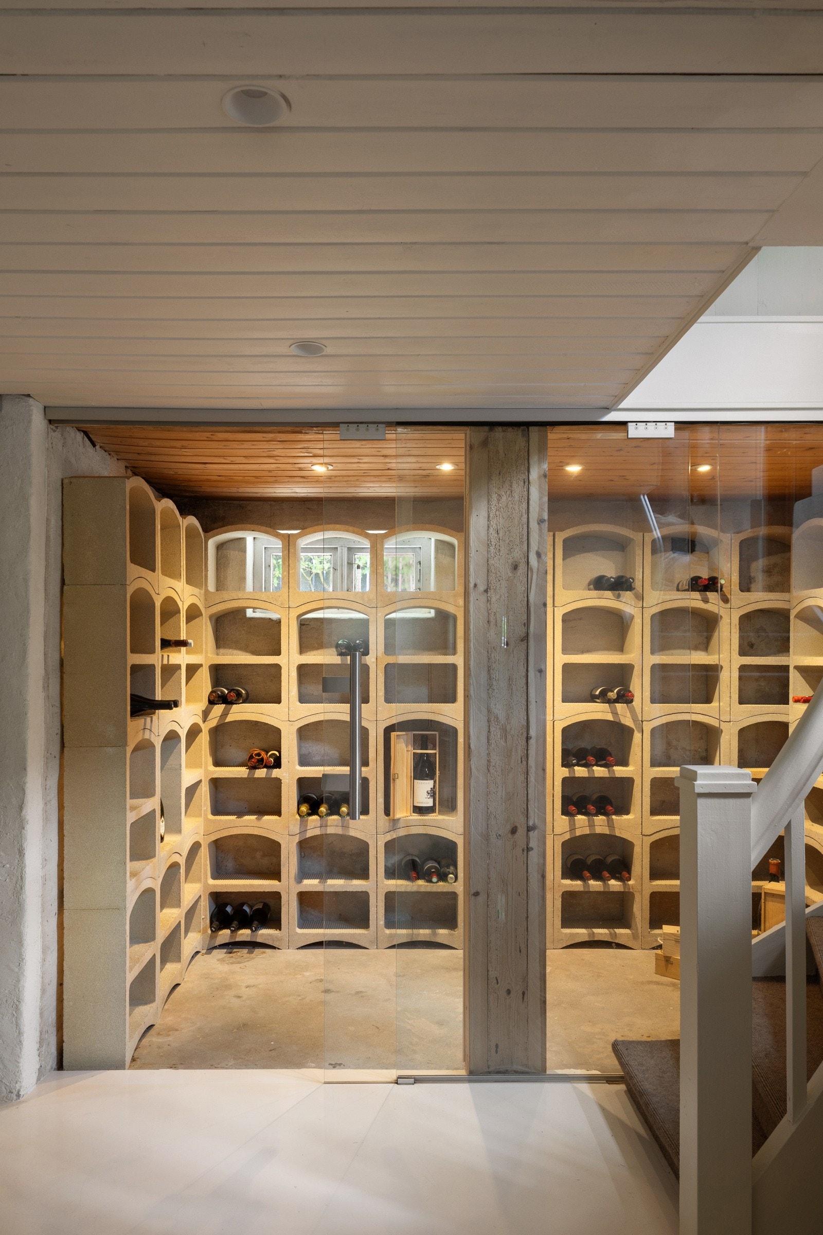 Vinrommet i underetasjen er adskilt med glassdører, har downlights i tak og rustikt betonggulv. Galleribilde