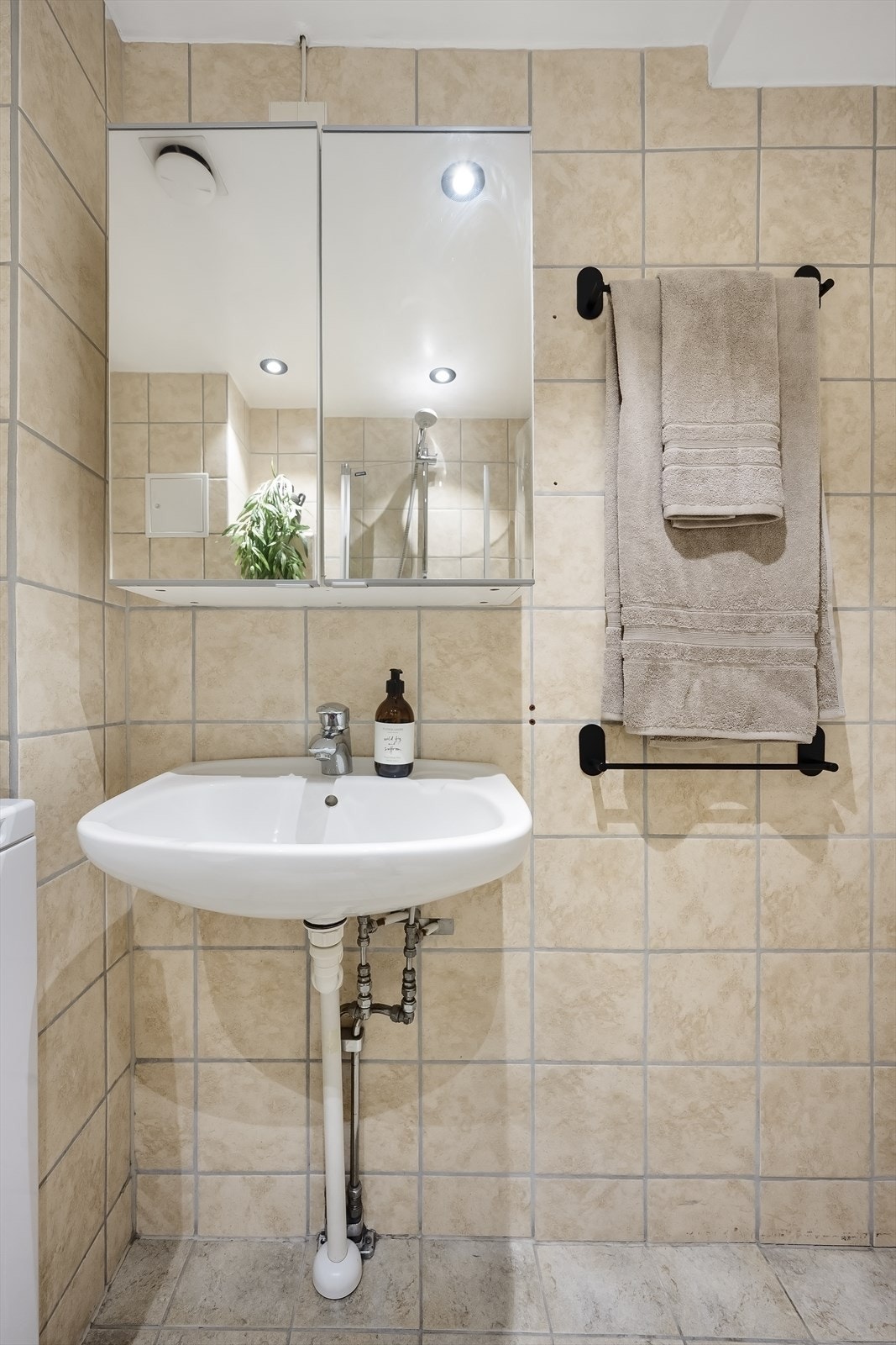 Badet er ellers utstyrt med dusjhjørne med innfellbare dusjdører, veggmontert toalett, servant og speilskap samt mekanisk avtrekk. Galleribilde