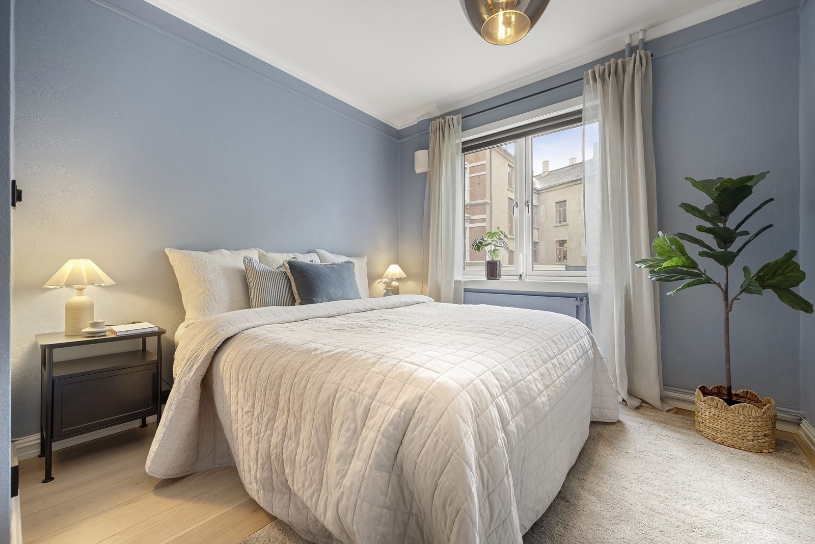 Lunt og pent soverom malt i en nydelig blåfarge. Galleribilde