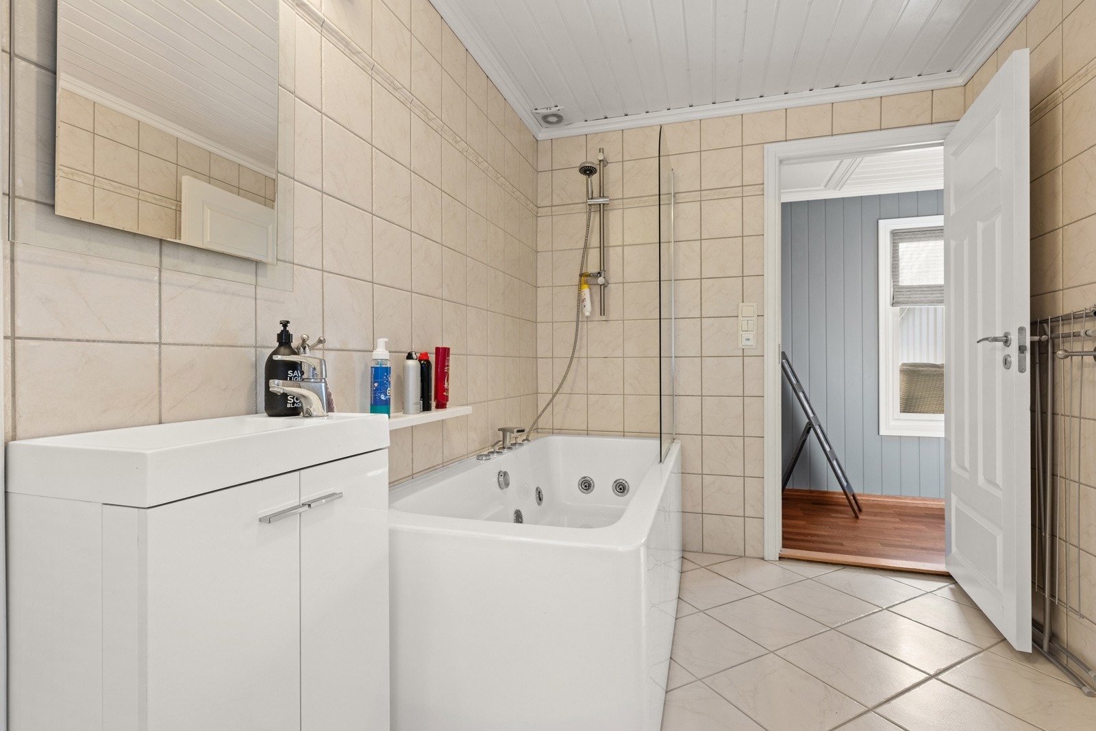 Lyst og fint bad/vaskerom med badekar og opplegg til vaskemaskin. Galleribilde