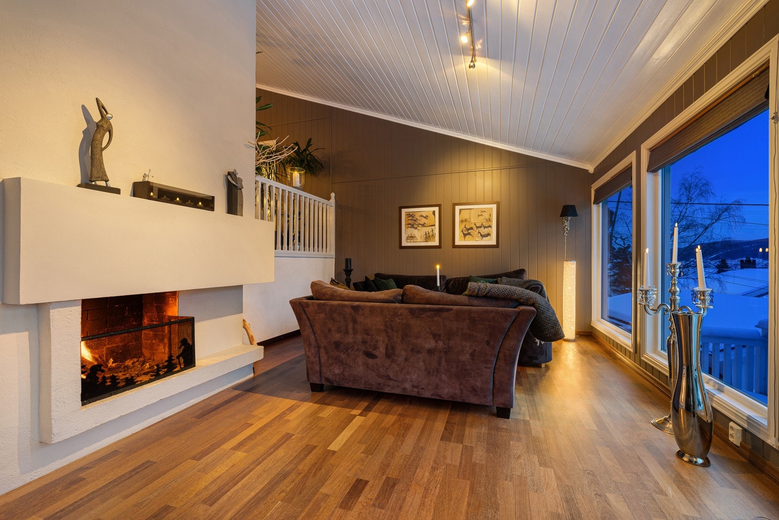 Lys og romslig stue med store vindusflater, peis og utgang til terrasse. Galleribilde