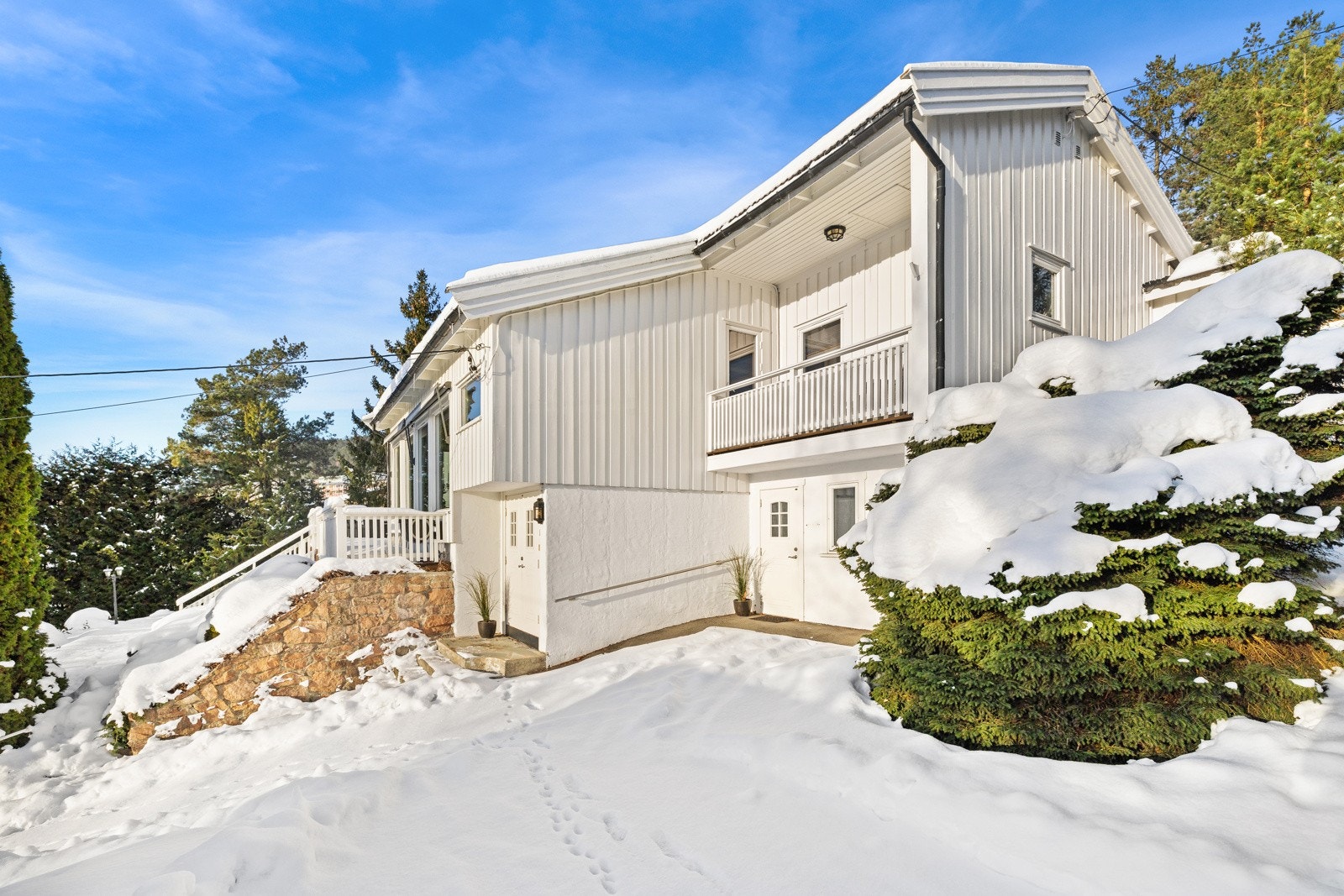 Boligen ligger fint til i skrånende terreng med opparbeidet adkomst og fine utearealer Galleribilde