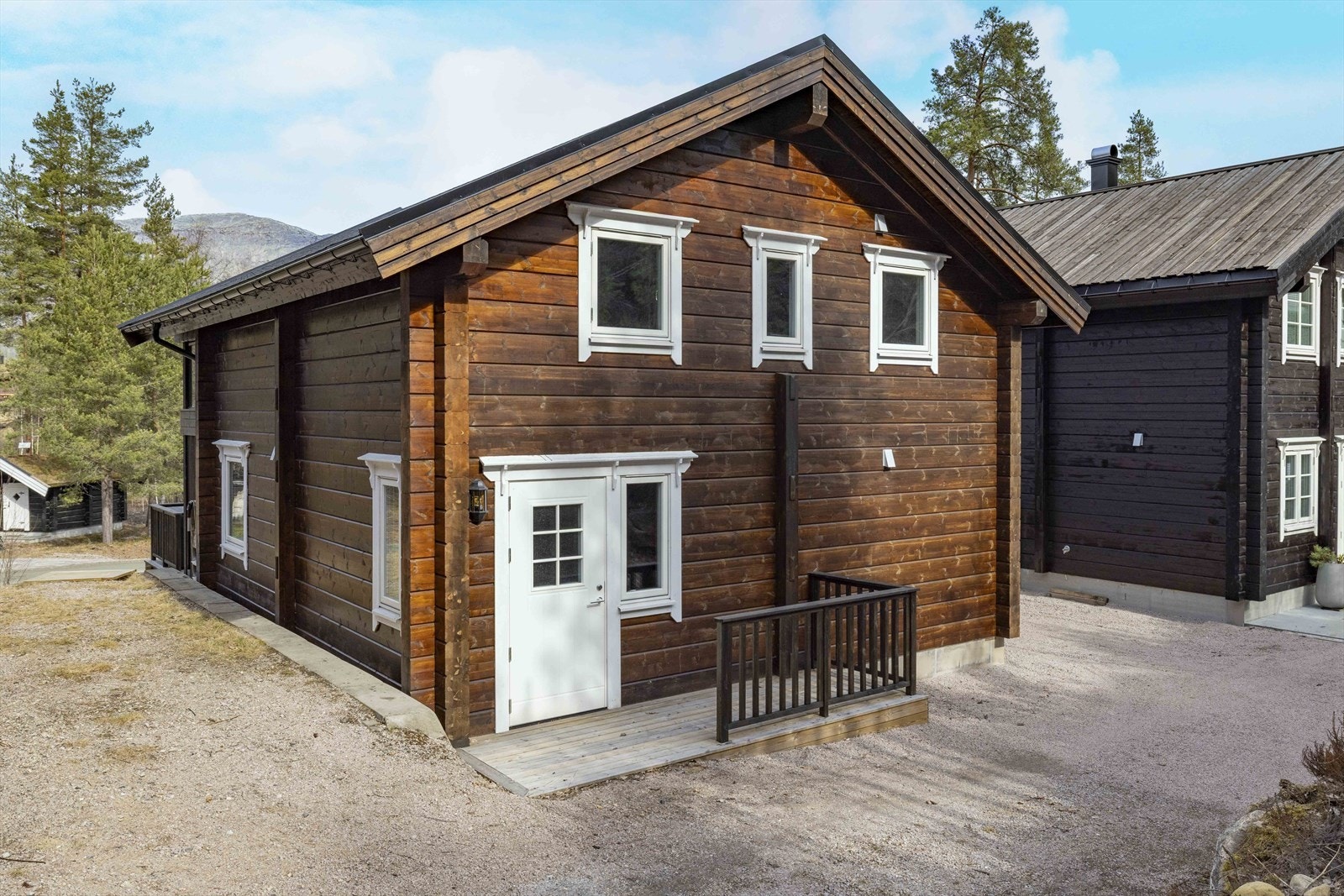 Gruslagt innkjørsel og egen parkeringplass langs hytteveggen ved inngangspartiet Galleribilde