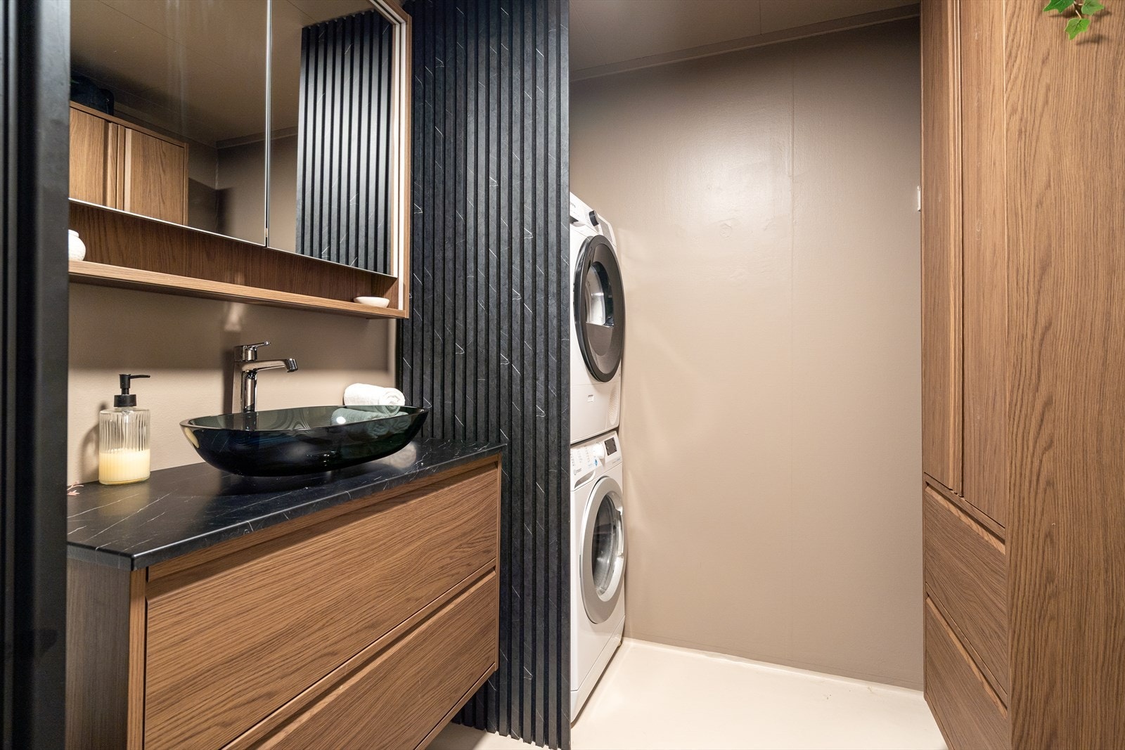 Vaskesøylen er skjult bak en stilig halvvegg med sorte spiler. Galleribilde