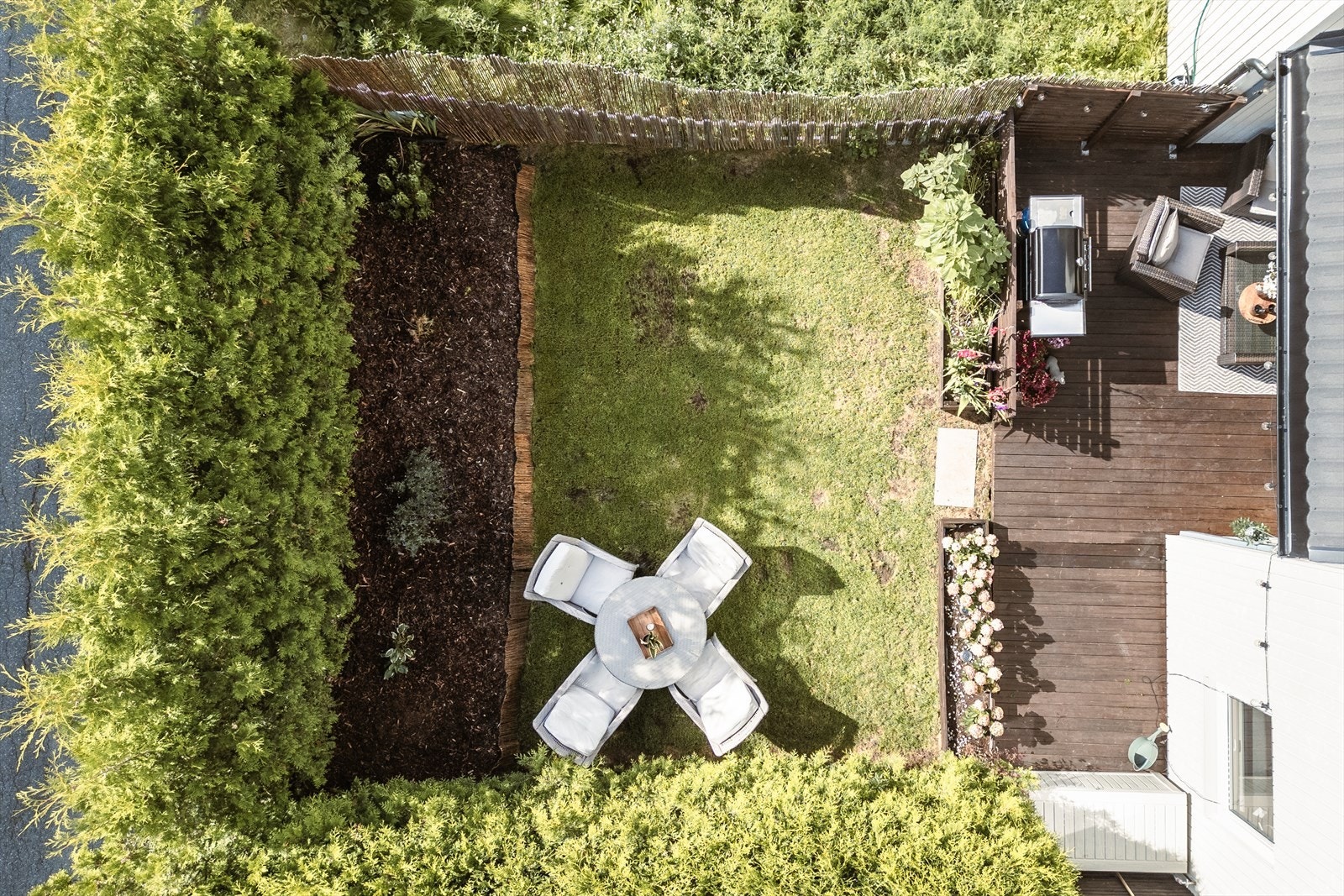 Uteområde vender mot sør - omkranset av høy hekk og bambusgjerde. Galleribilde