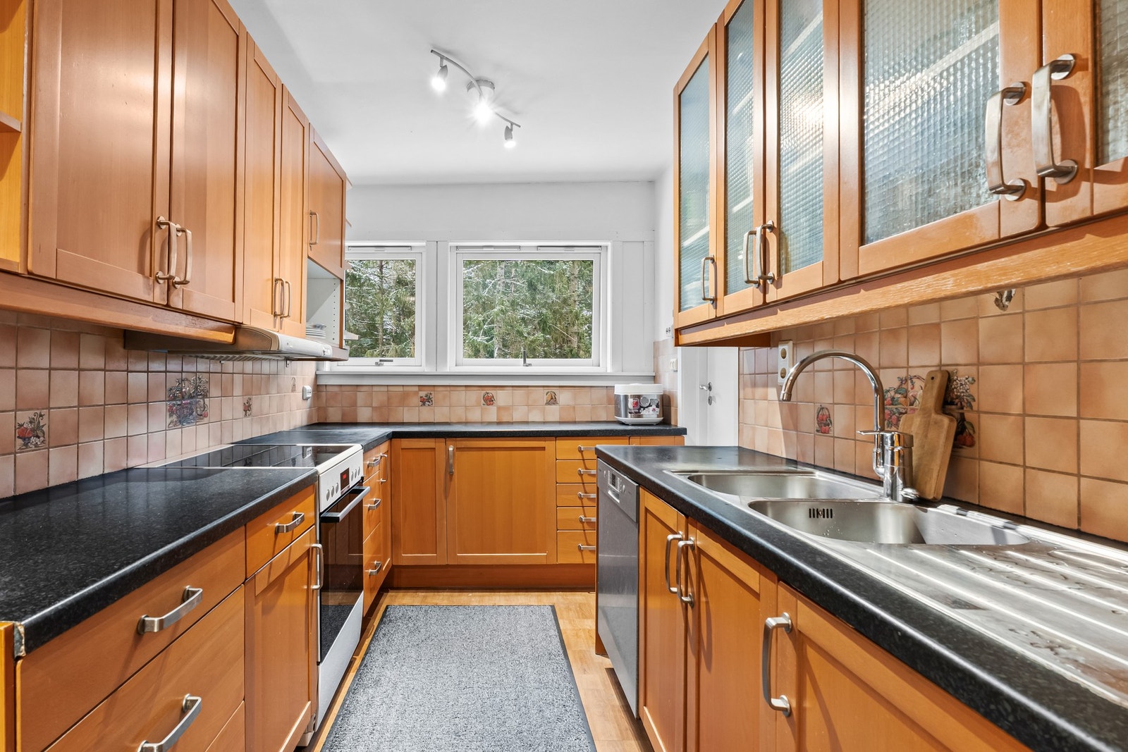 Stort adskilt kjøkken med store vindusflater og godt med skap- og benkeplass Galleribilde