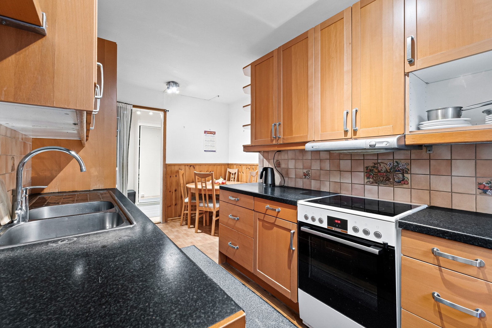 Kjøkkenet er utstyrt med komfyr med platetopp, oppvaskmaskin og frittstående kjøl/fryseskap Galleribilde