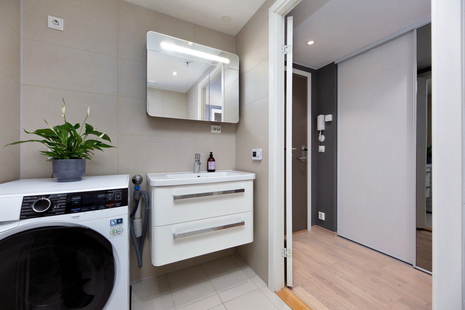 Vegghengt servantinnredning med heldekkende servant og speilskap med belysning. Galleribilde