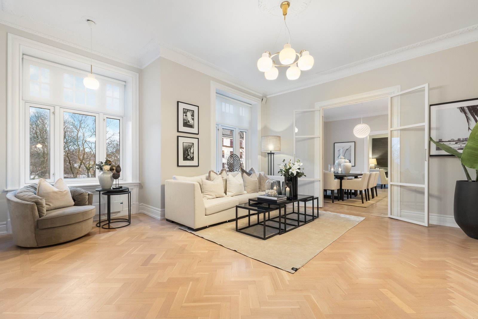 Ekspansiv stue med vakker stukkatur, rosetter og store vinduer som slipper inn rikelig dagslys. Galleribilde