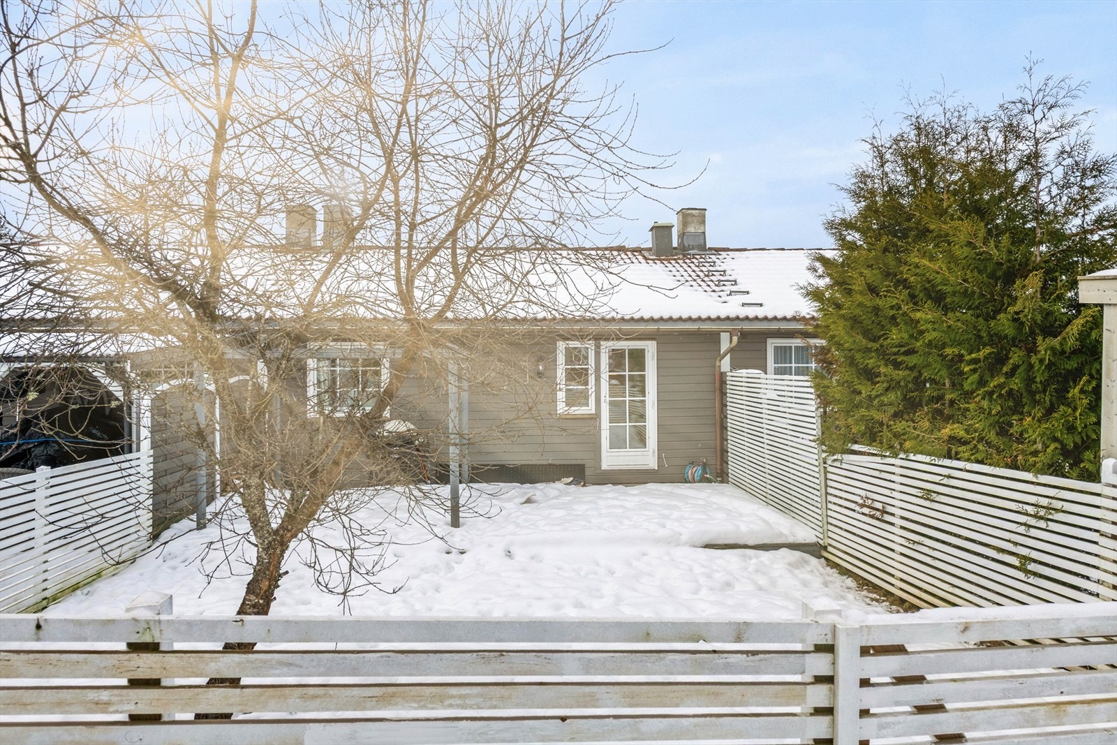 Boligen skiller seg ut ved å ha en stor hage med flat gressplen og platting Galleribilde