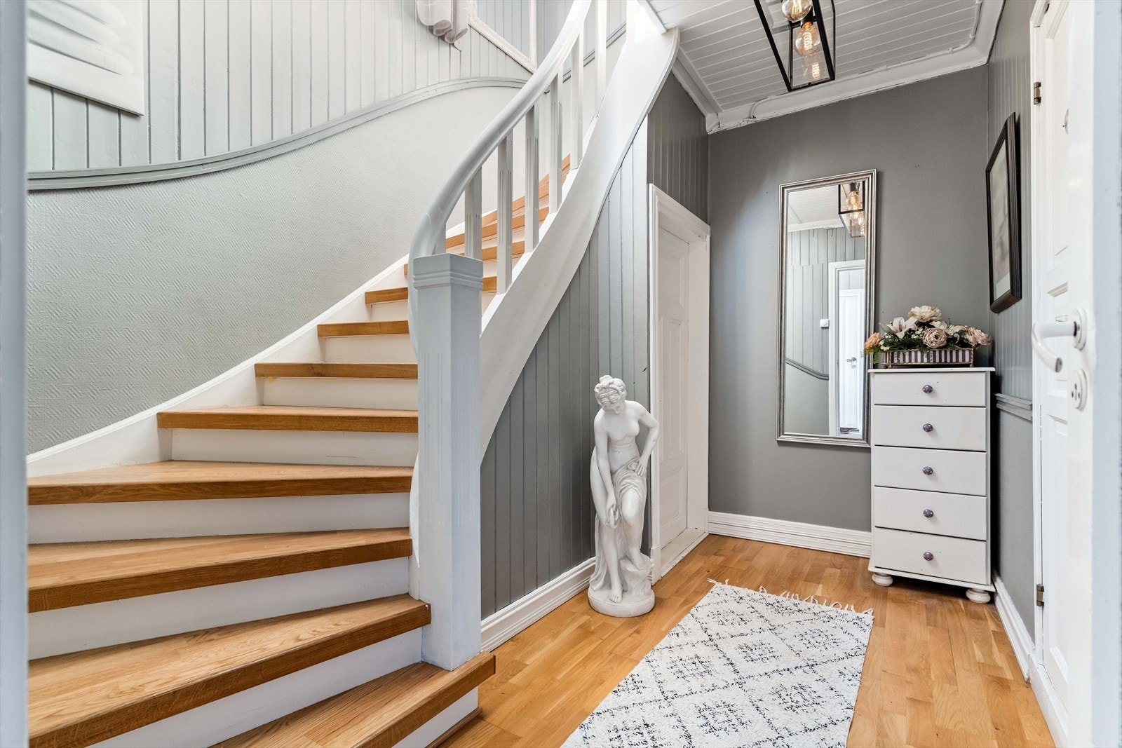 Gangen i 1. etasje er romslig. Herfra er det tilgang til kjeller, bad samt trapp opp til hoveddelen av boligen. Galleribilde