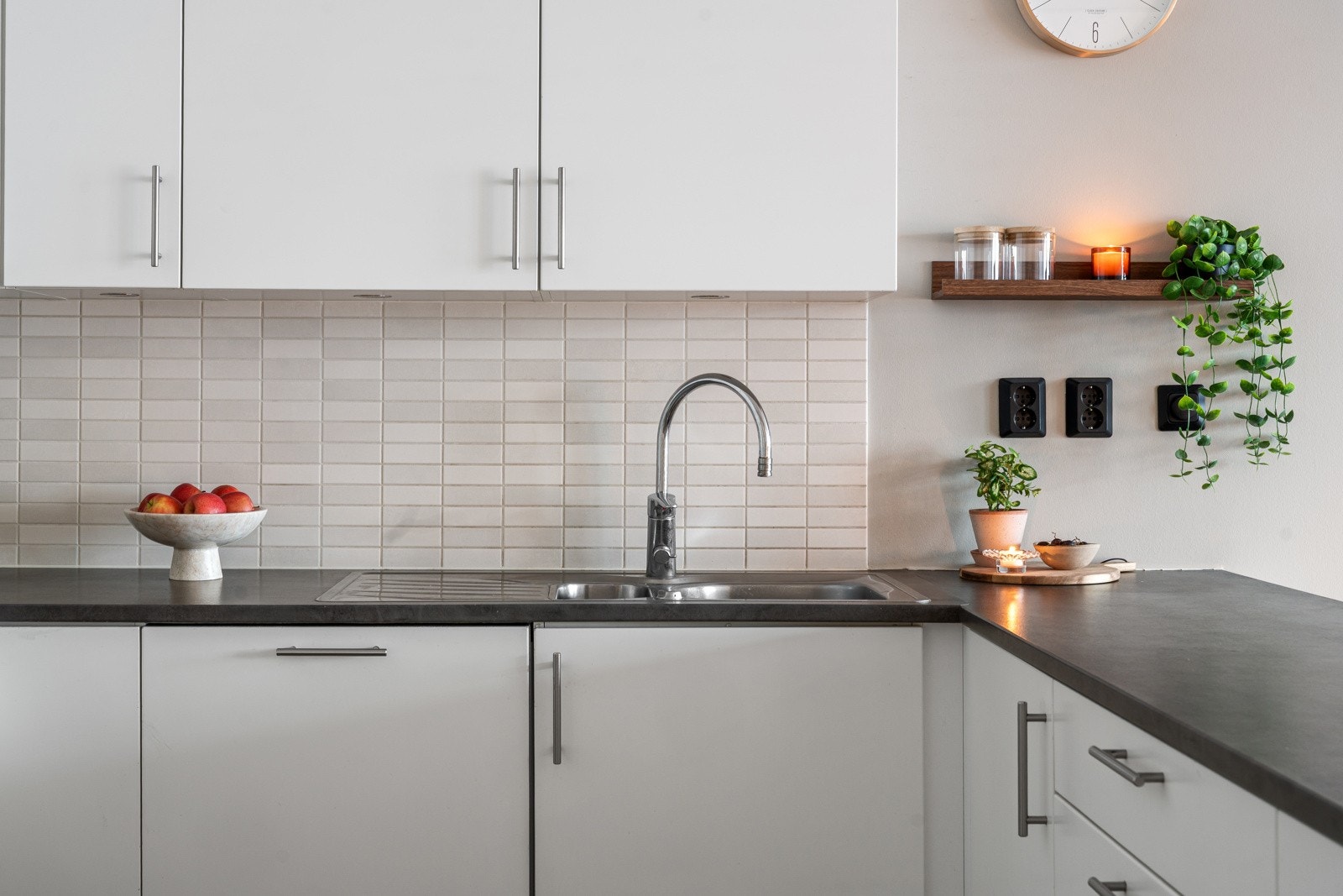 Lys kjøkkeninnredning med lyse fronter, laminat benkeplate og rikelig med skuffer, skap og benkeplass.