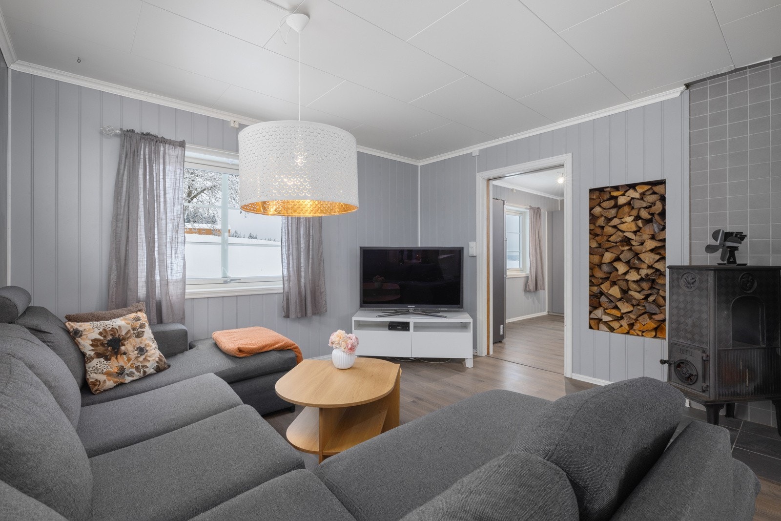 Hyggelig sofakrok med vedskap integrert i veggen ved ovnen. Galleribilde