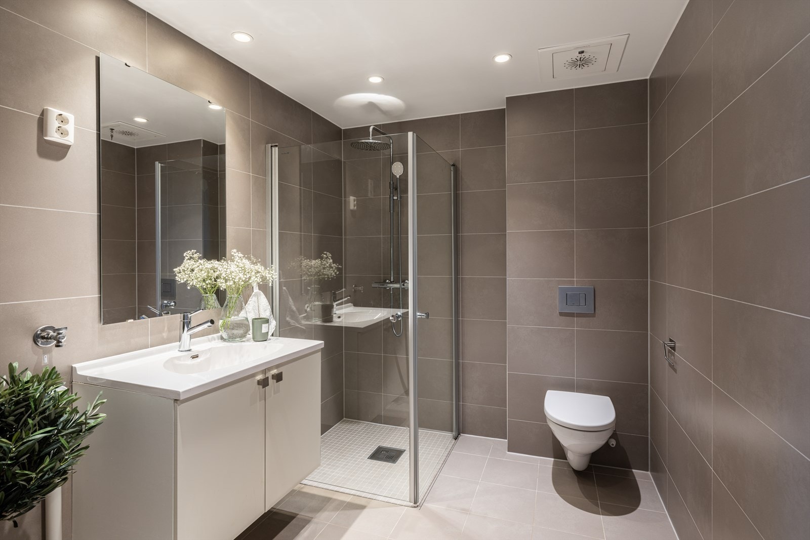 Delikat baderom i hybeldelen med pene fliser på gulv og vegger Galleribilde