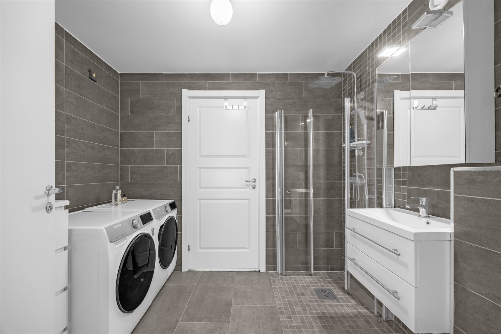 Innbydende og pent bad som er overflateoppusset med nye fliser i 2018. Det er opplegg og plass for vaskemaskin og tørketrommel. Disse medfølger ikke. Galleribilde