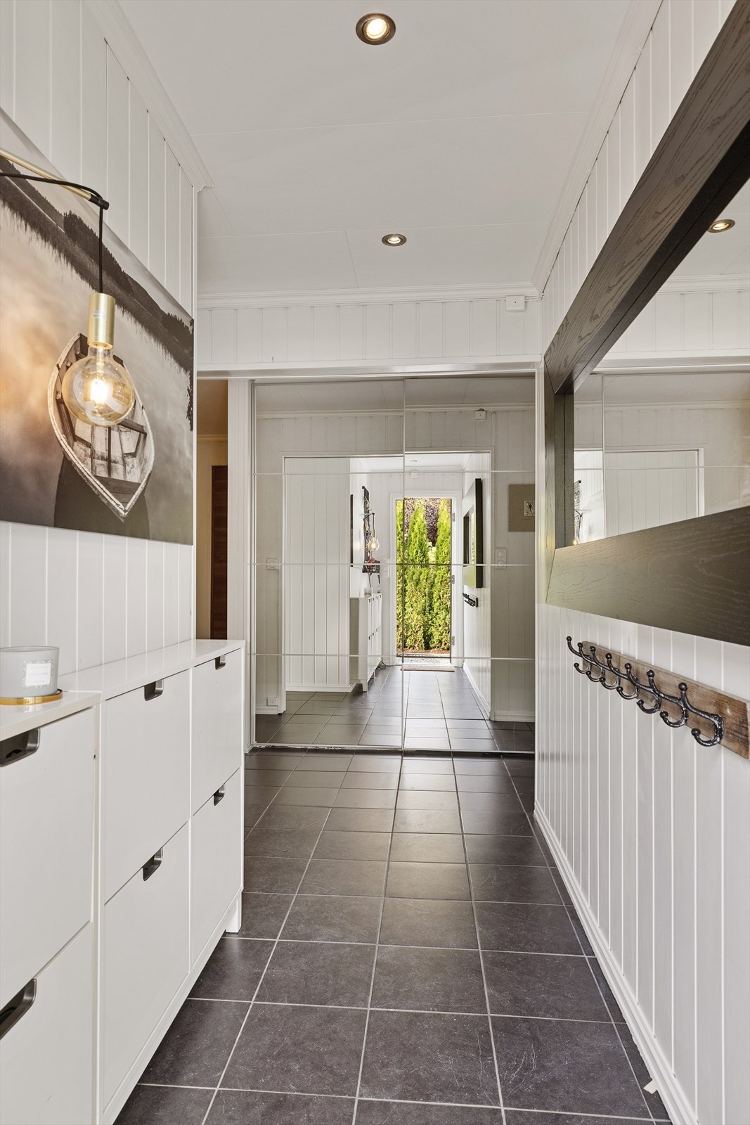 Man ønskes velkommen inn i en flislagt entré med plass til å henge fra seg yttertøy. Galleribilde