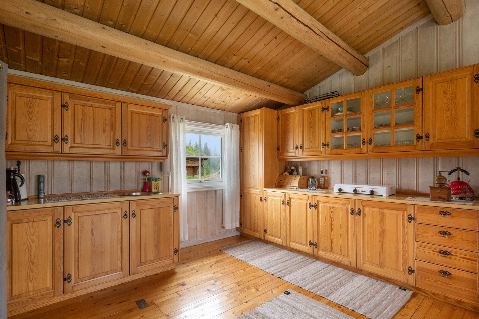 Kjøkkenet er enkelt og funksjonelt med laminerte skrog og profilerte fronter, kjøkkenkum, og plass til frittstående kjøleskap og kokebluss Galleribilde