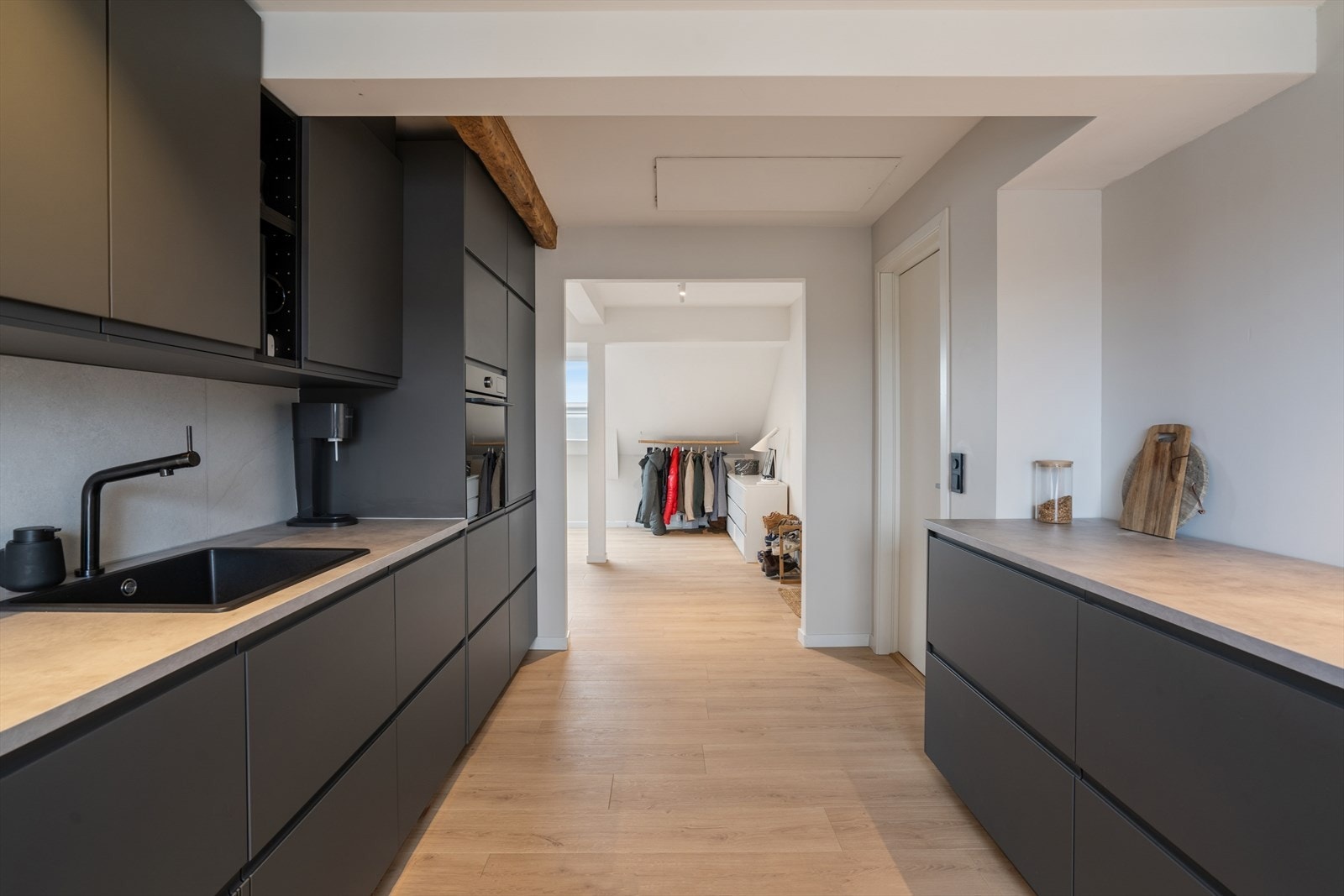 Mellom benkeplaten og overskapene finner du et elegant, flislagt felt som både løfter uttrykket og gir en praktisk, slitesterk løsning. Galleribilde