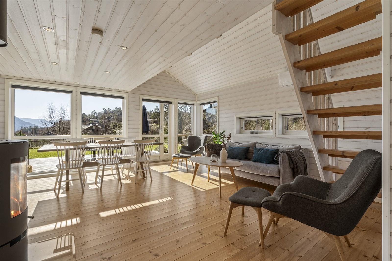 Stua har gode vindu som gir deilig lys, god vedovn og god plass til spisegruppe og salong. Spotter i tak. Galleribilde