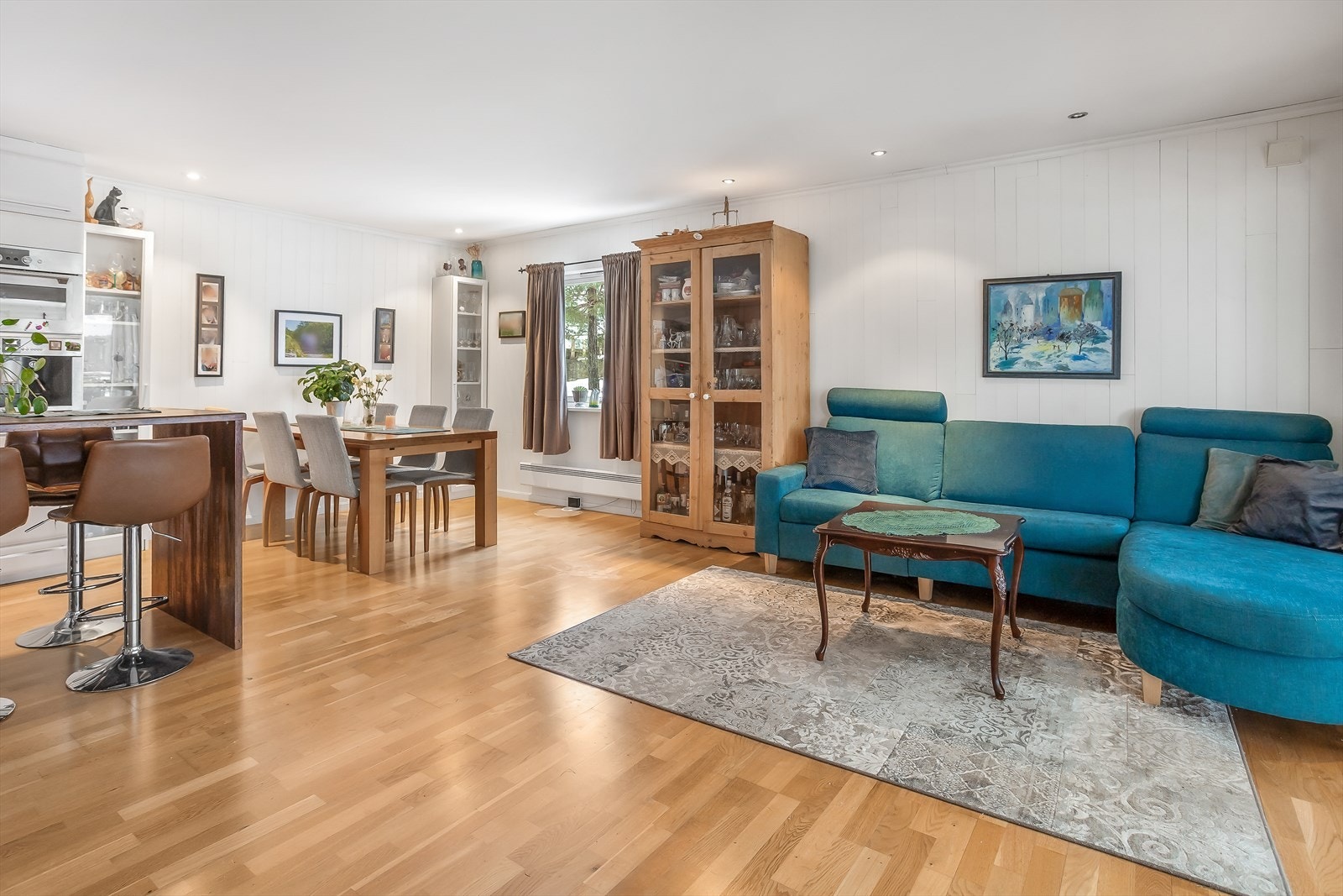 Stuen har parkett på gulv og hvit malt panel på vegger. Galleribilde