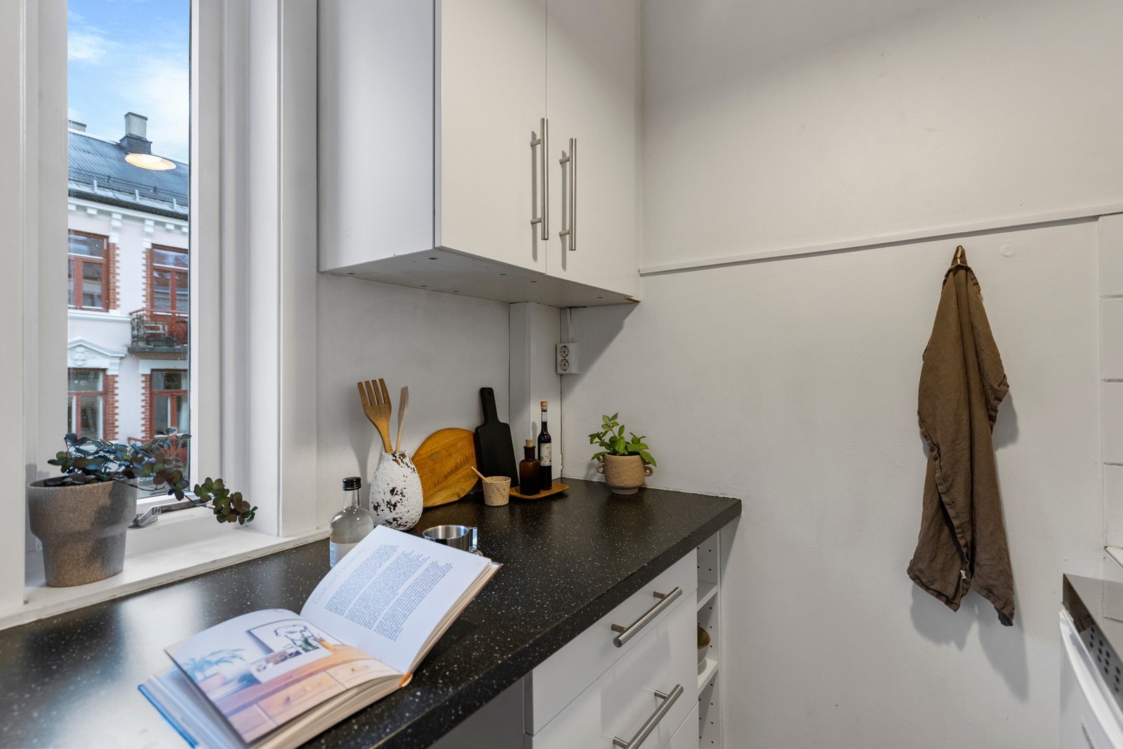 Medfølgende hvitevarer består av kjøleskap, platetopp og frittstående stekeovn. Løsningen gir god utnyttelse av rommet og byr på rikelig med skap- og benkeplass. Galleribilde