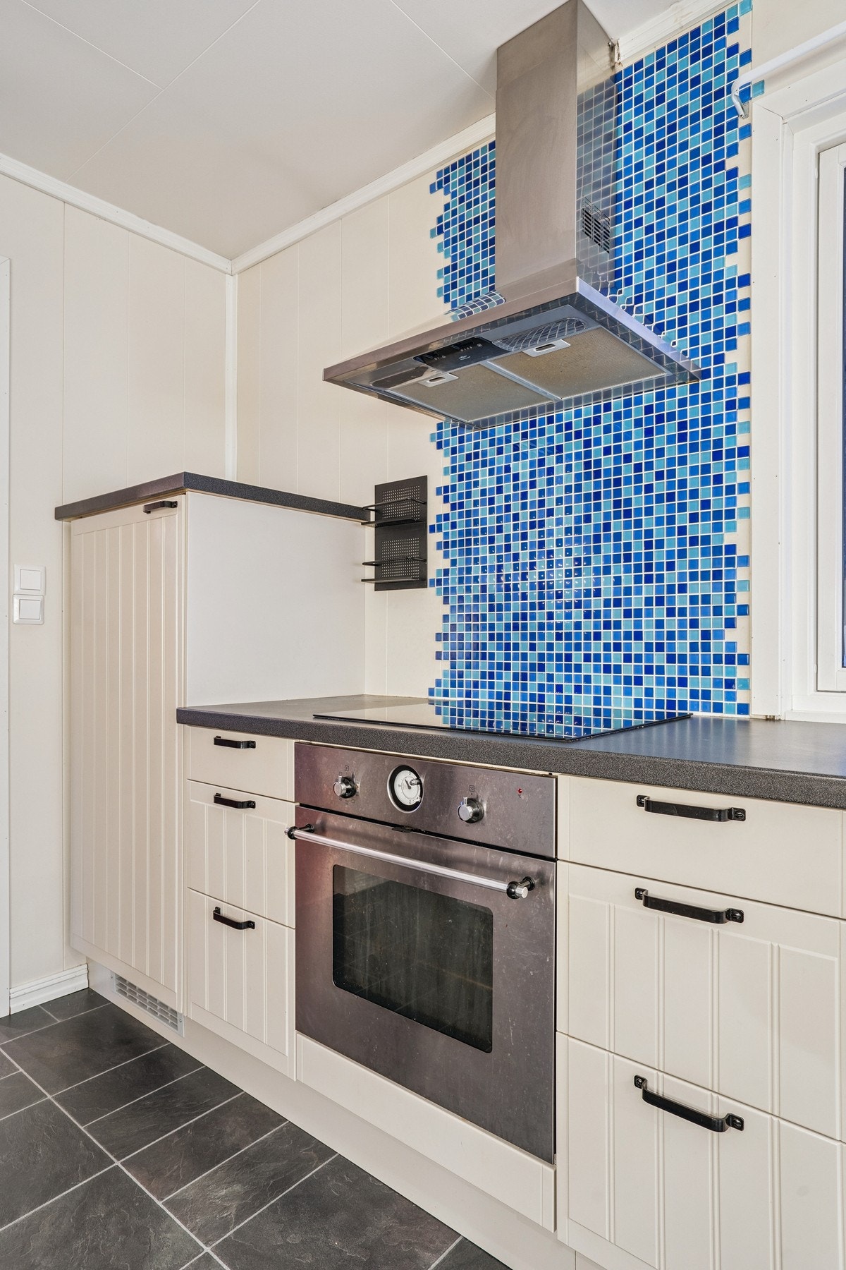 Kjøkkenet er utstyrt med en ventilator i rustfritt stål over kokesonen. Galleribilde