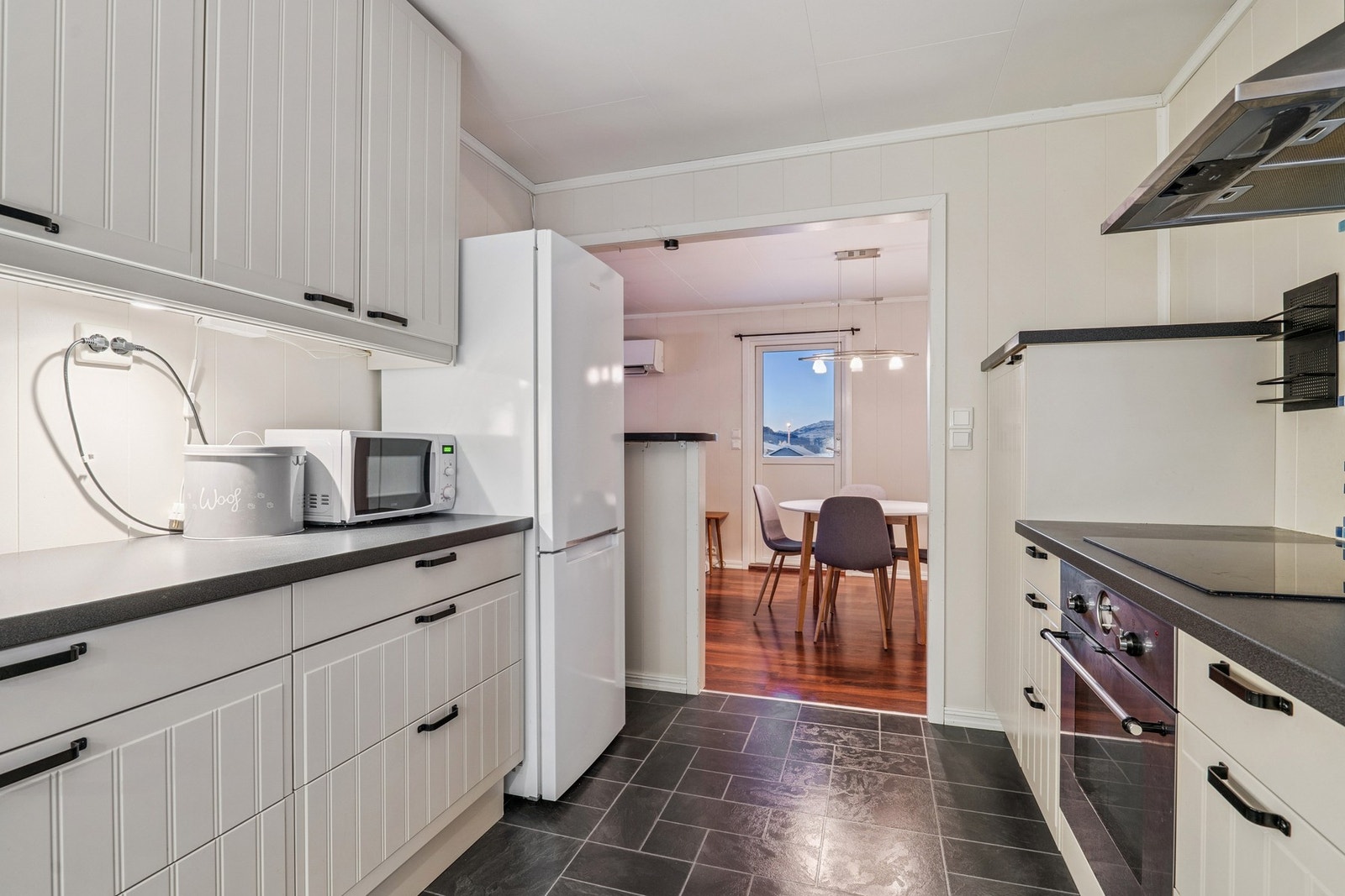 Kjøkkenet har en åpen forbindelse mot spisestuen, noe som skaper en sosial sone. Galleribilde