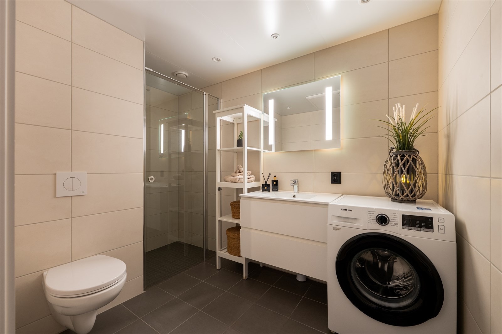 Fra gangen kommer man inn til et flott bad. Badet er en prefabrikkert baderomskabin og har fliser på vegger og gulv med vannbåren gulvvarme. Galleribilde