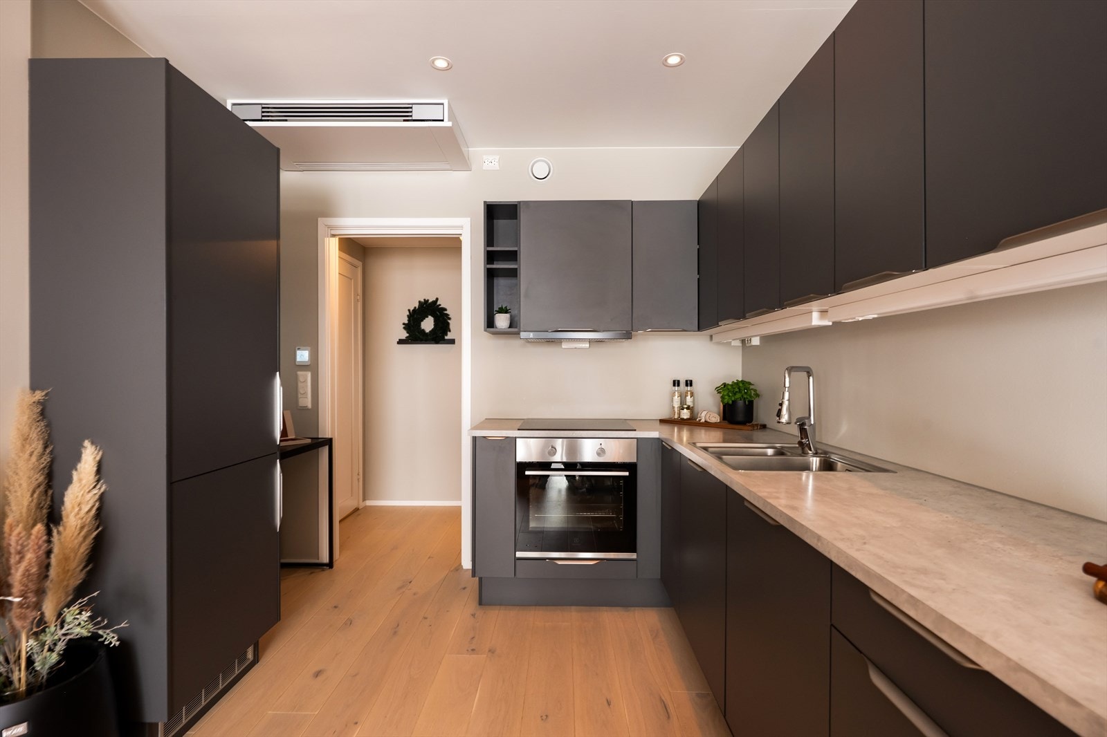 Flott kjøkkeninnredning fra Norema med mørke, stilrene fronter og laminat benkeplate. Galleribilde