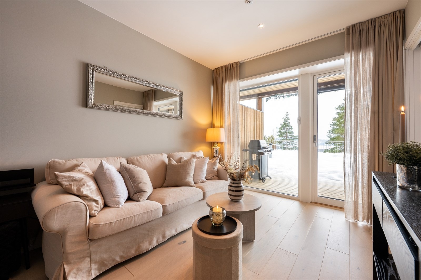 Det er naturlige soner for både sofagruppe og TV-møblement i stuen. Downlights i tak og store vindusflater som gir godt med lys. Galleribilde