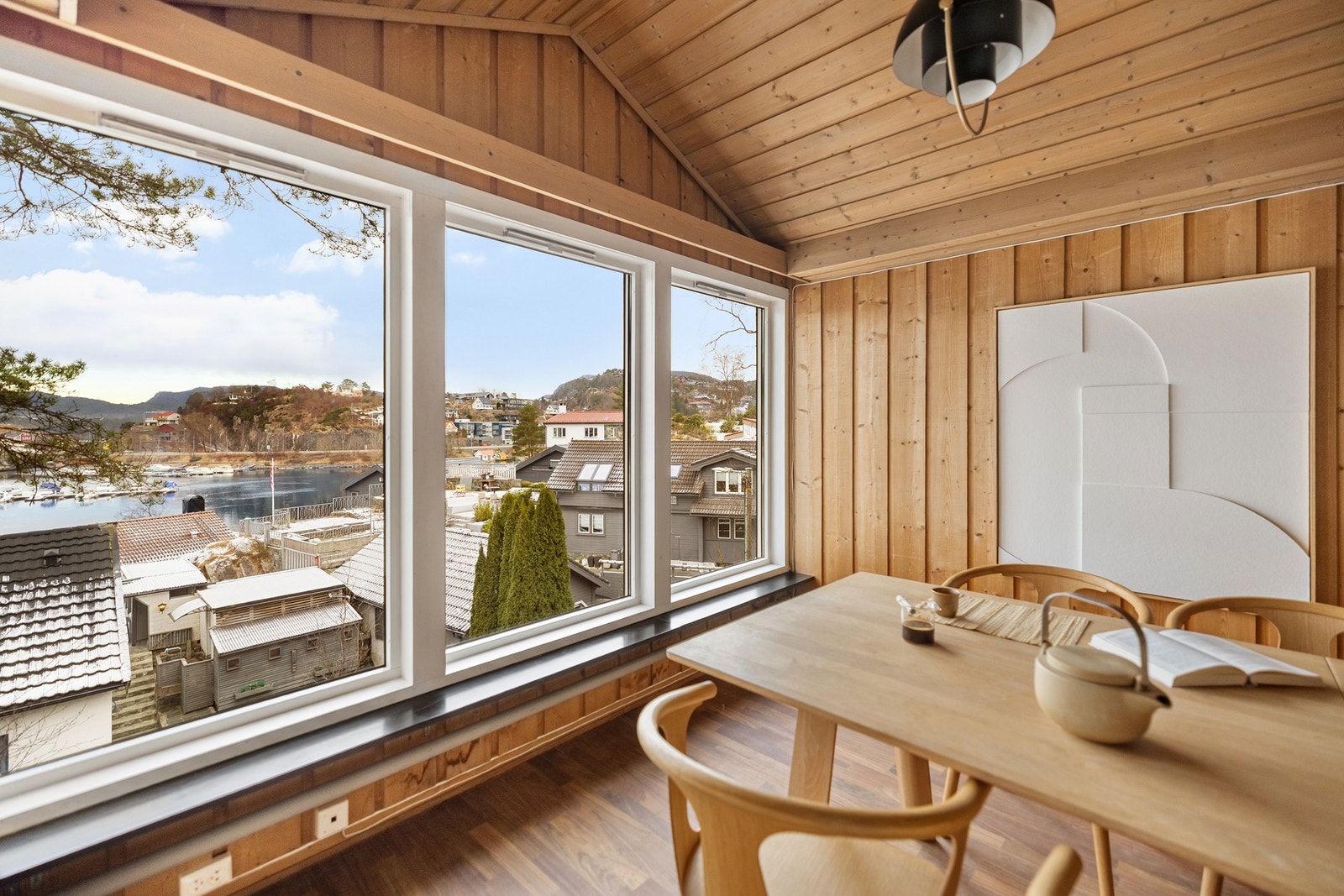 De store vindusflatene slipper inn den nydelige utsikten over sjøen og båtforeningen. Galleribilde