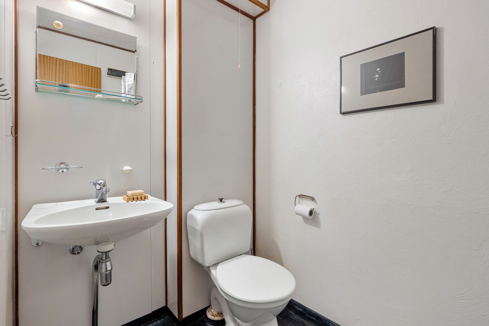 Like ved inngangspartiet finner vi et toalettrom med toalett, servant, speil og belysning. Galleribilde