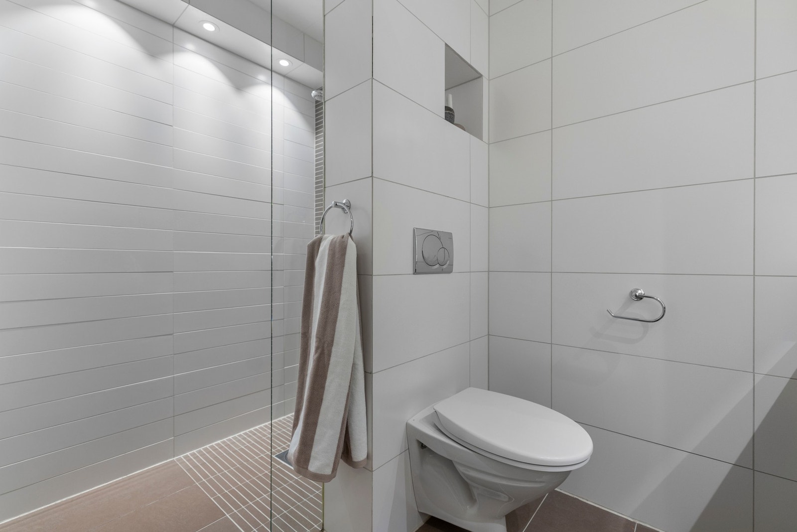 Leilighetens baderom har flislagte vegger og gulv med behagelige varmekabler. Innredningen består av servant med underskap, speil, vegghengt toalett, dusj sone samt opplegg til vaskemaskin. Galleribilde