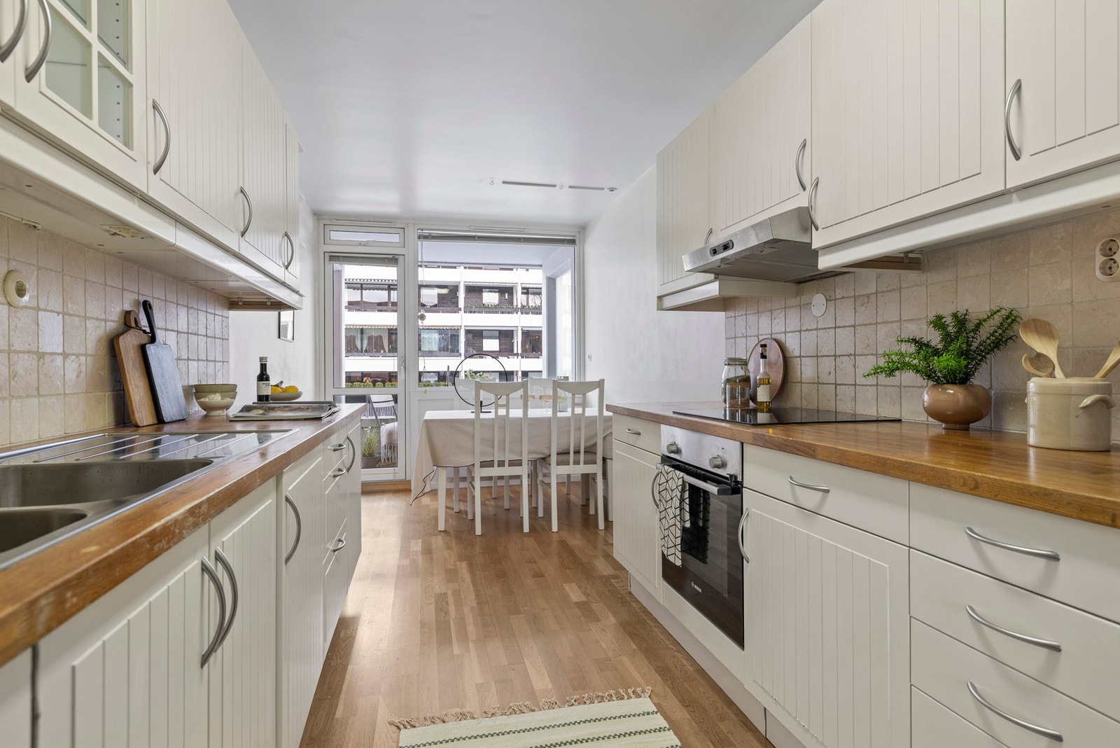 Kjøkkenet fremstår som praktisk. Her får du en innredning med trebenkeplater, flislagt backsplash og profilerte fronter som gir et tidløst preg. Galleribilde