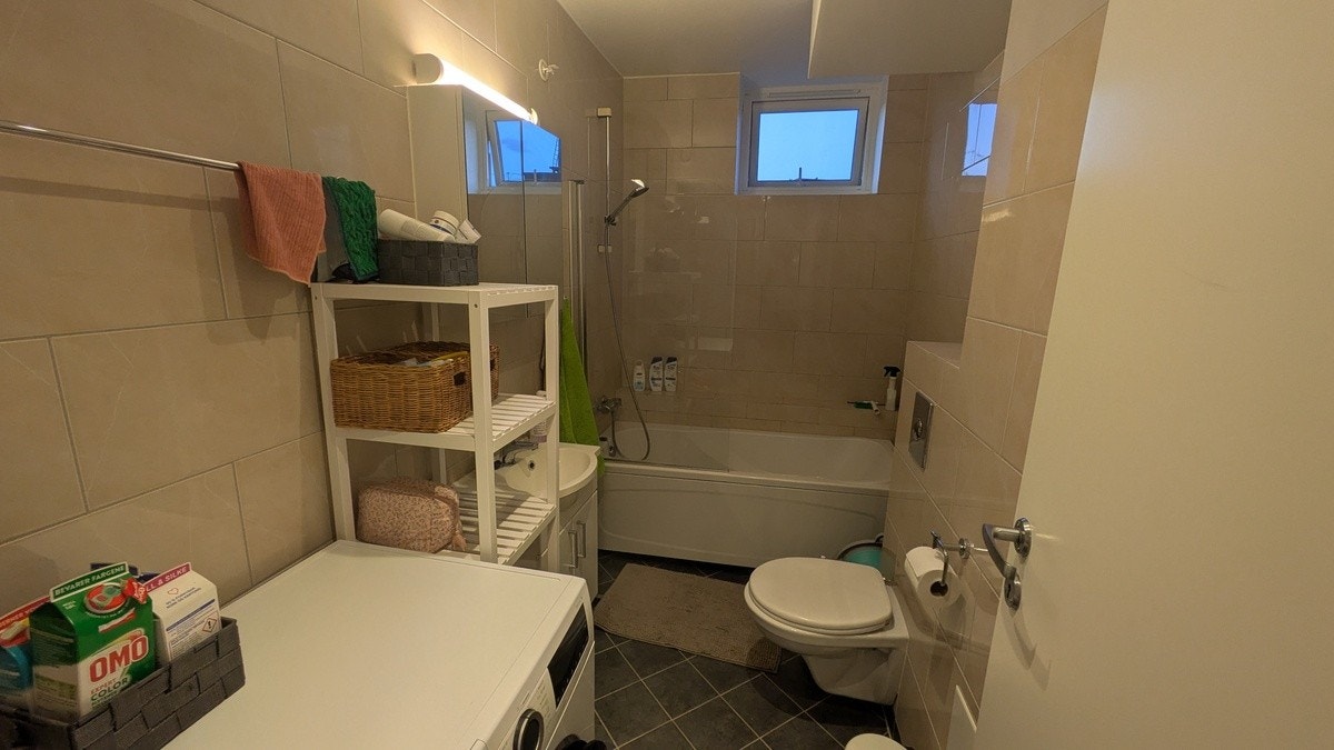 Bad med vaskemaskin og badekar Galleribilde